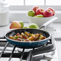 Sausage and potato dish cooking in the Merten & Storck Steel Core Enameled 9.5" Frypan in the color Aegean Teal. 