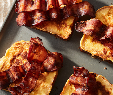Four slices of French toast topped with bacon strips