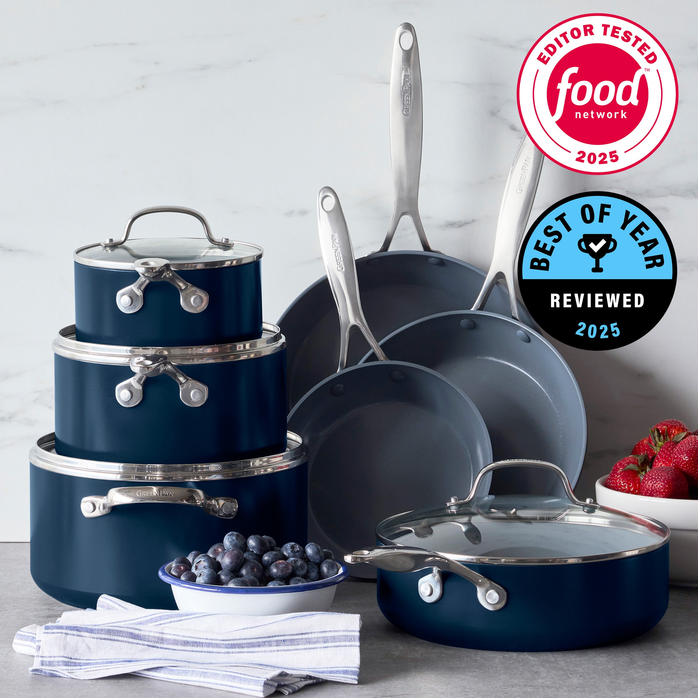 Blue ceramic nonstick 11-piece cookware set with glass lids displayed on kitchen counter; awards visible above.