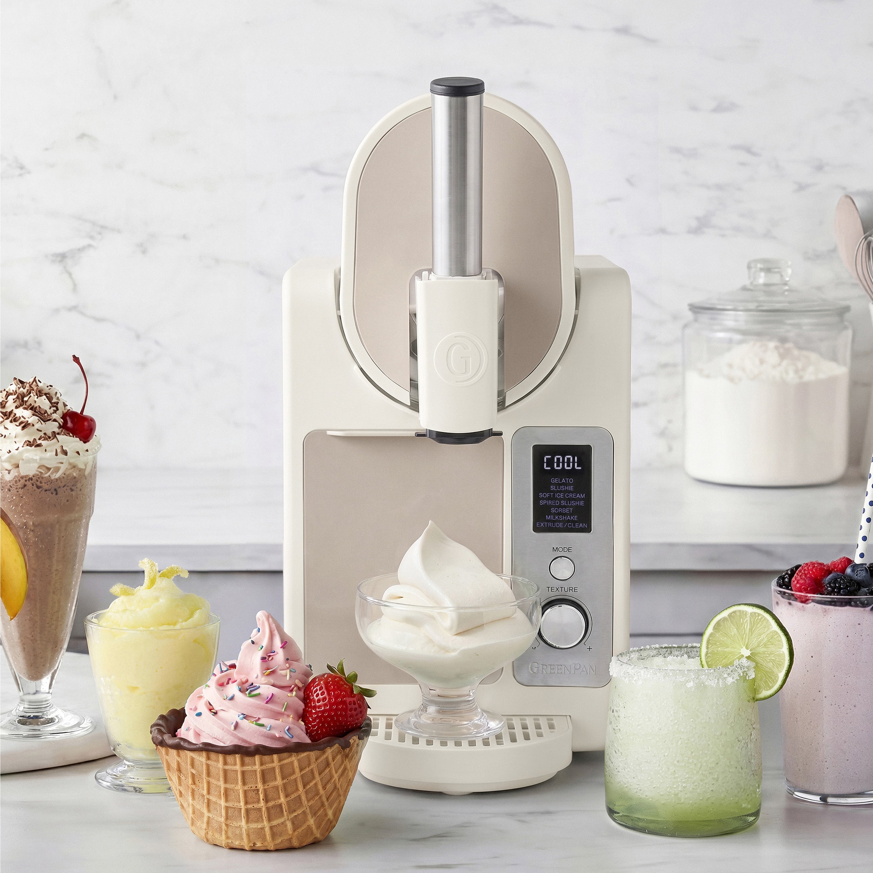 Ice cream maker with ice cream and desserts on a marble countertop