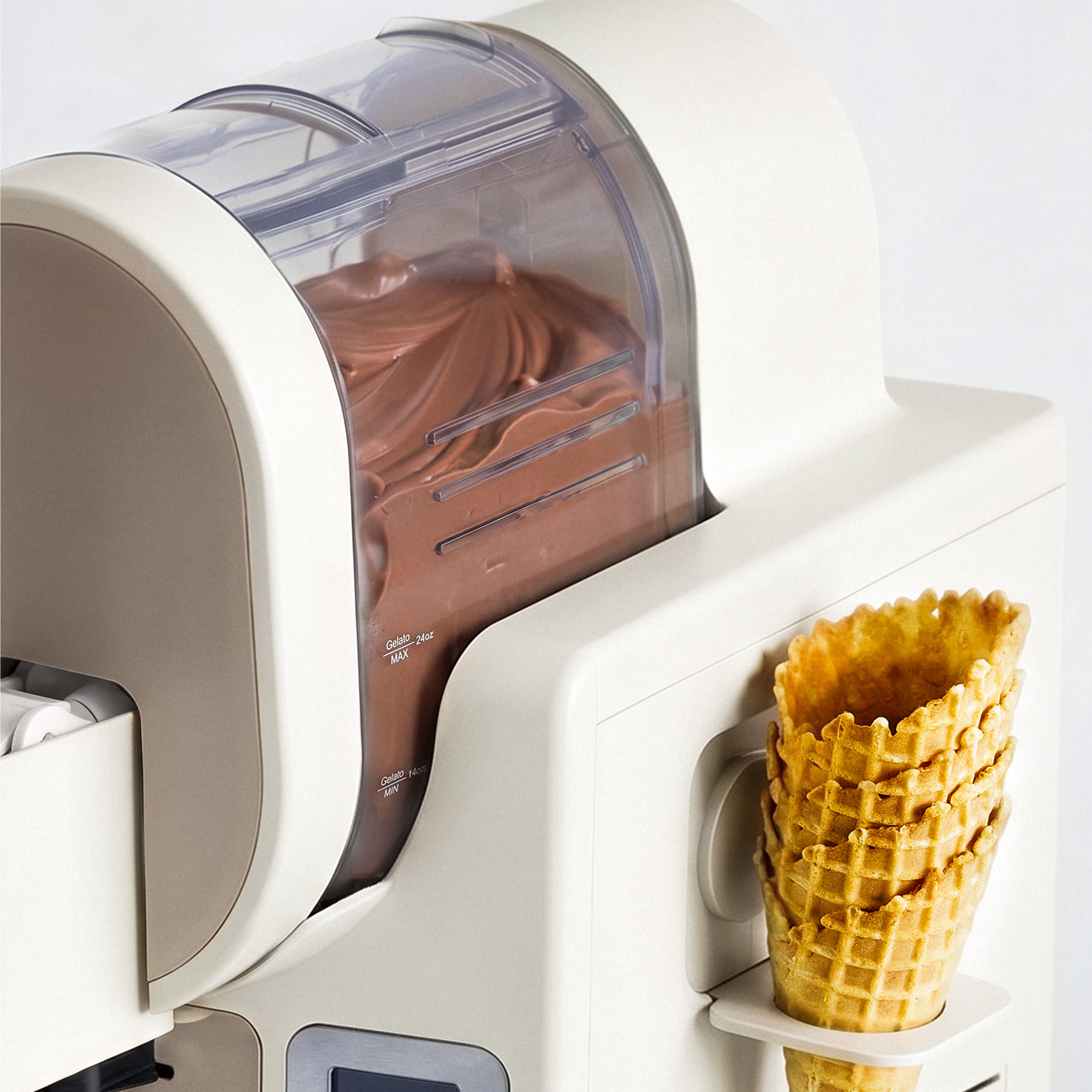 Ice cream machine dispensing chocolate ice cream into waffle cones 