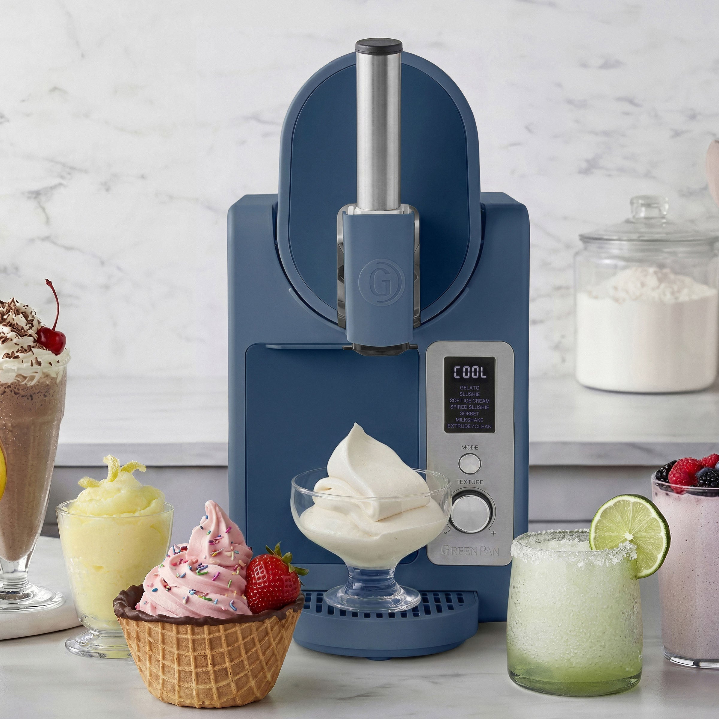 Ice cream maker with ice cream and desserts on a marble countertop