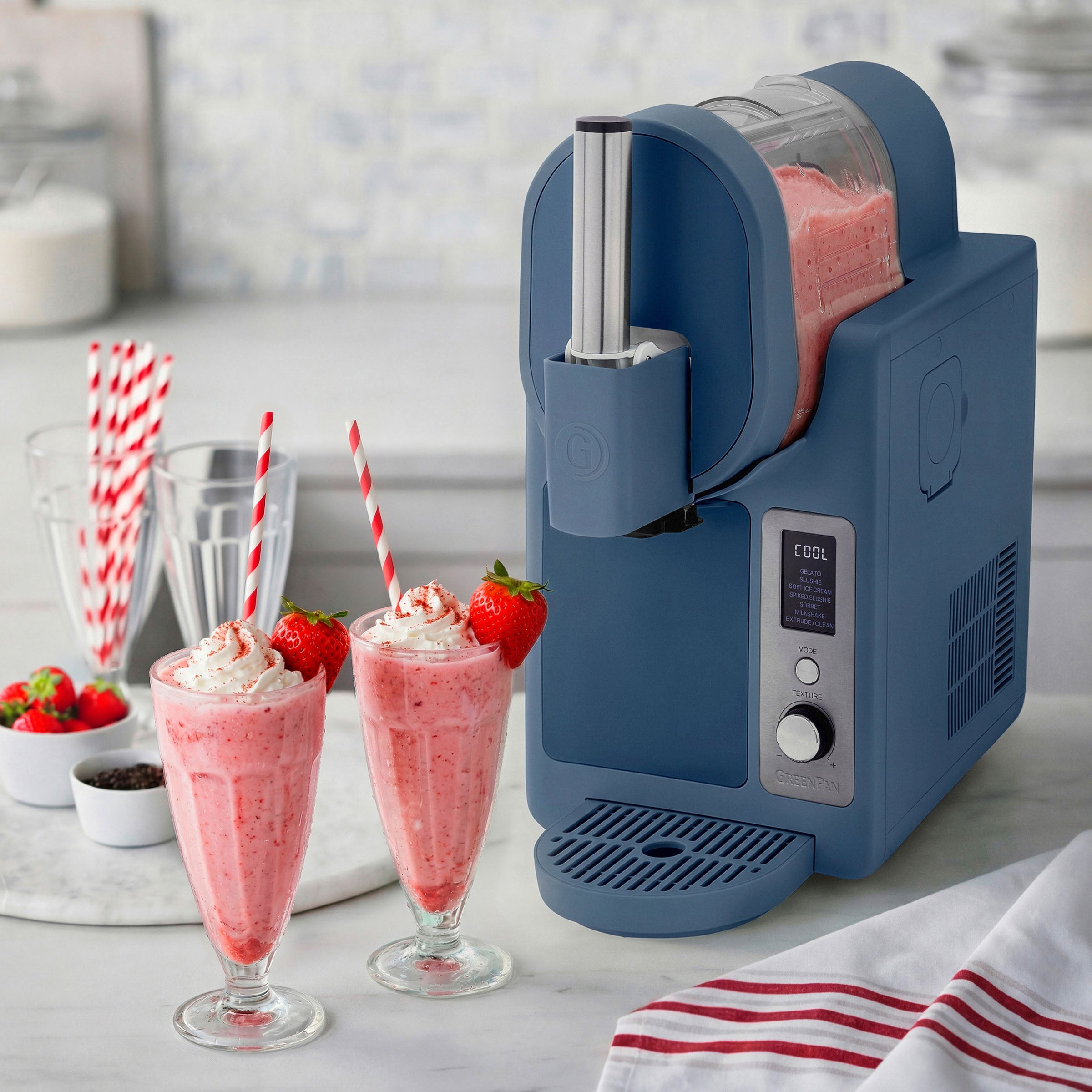 Ice cream machine with strawberry milkshakes on a kitchen counter