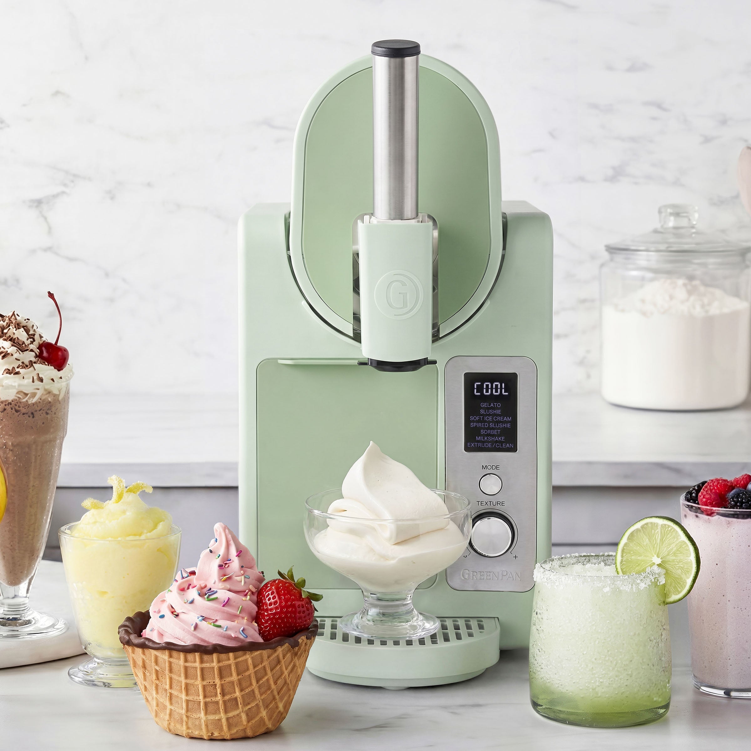 Ice cream maker with ice cream and desserts on a marble countertop