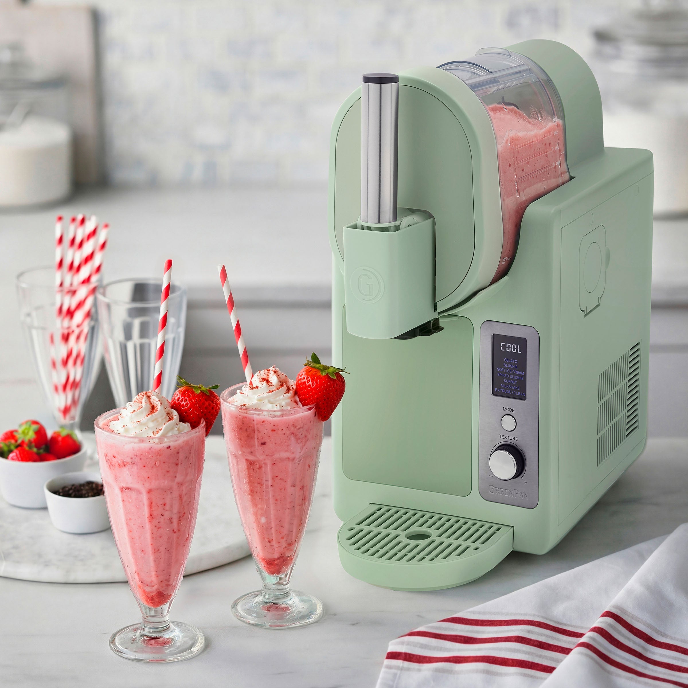 Ice cream machine with strawberry milkshakes on a kitchen counter