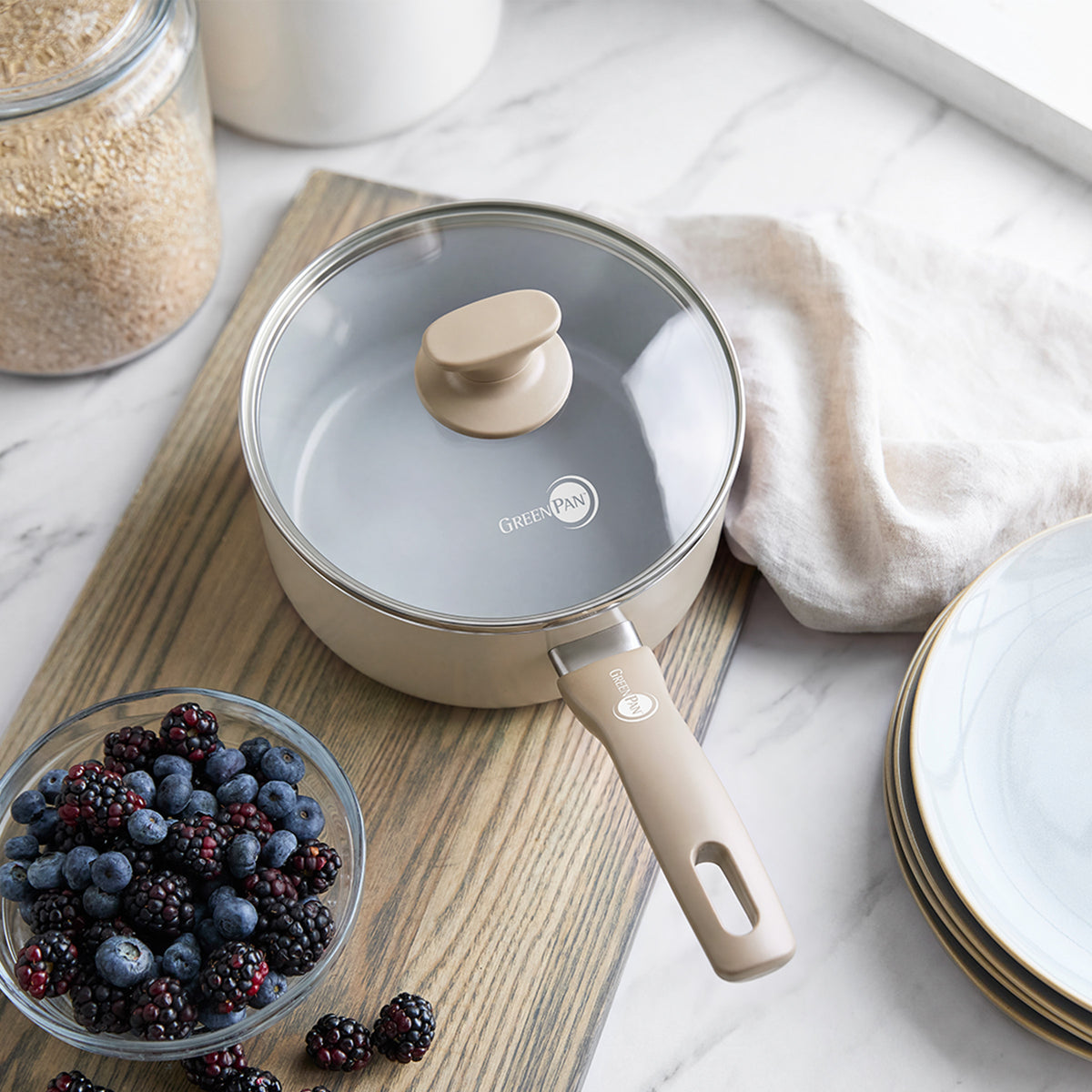 Taupe ceramic 2.25-quart saucepan with matching lid, nonstick finish, shown on a kitchen surface.
