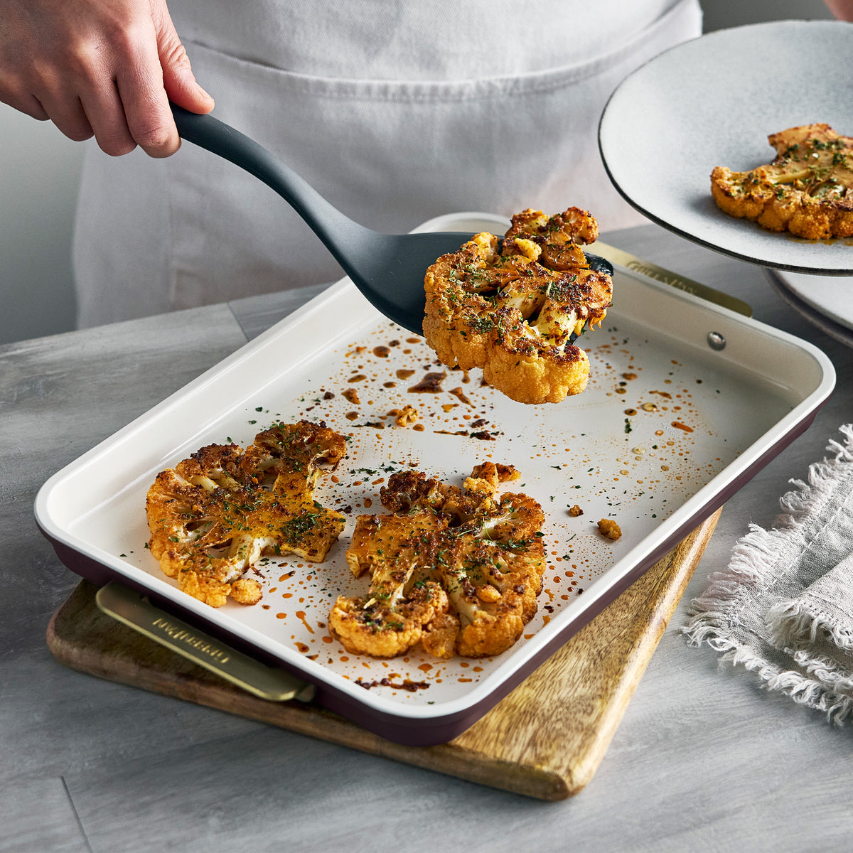 Spatula lifting roasted cauliflower from a Bordeaux Reserve Bakeware 13″ x 9″ quarter sheet pan.