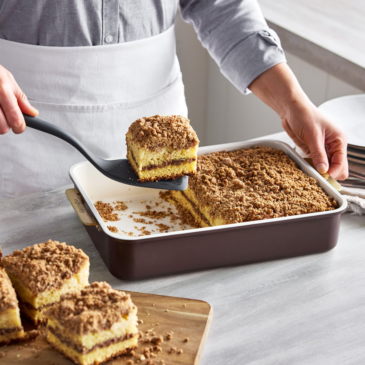 A spatula lifting a slice of coffee cake from a Bordeaux Reserve Bakeware 8-piece aluminized steel pan.