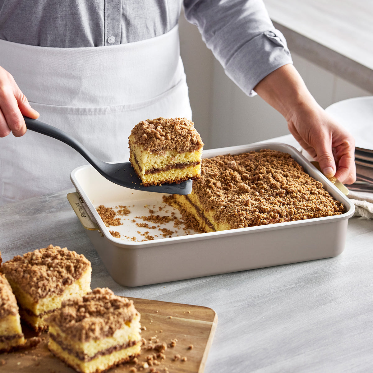 A slice of crumb cake being lifted with a spatula from a Latte Reserve Bakeware 7-piece aluminized steel pan.