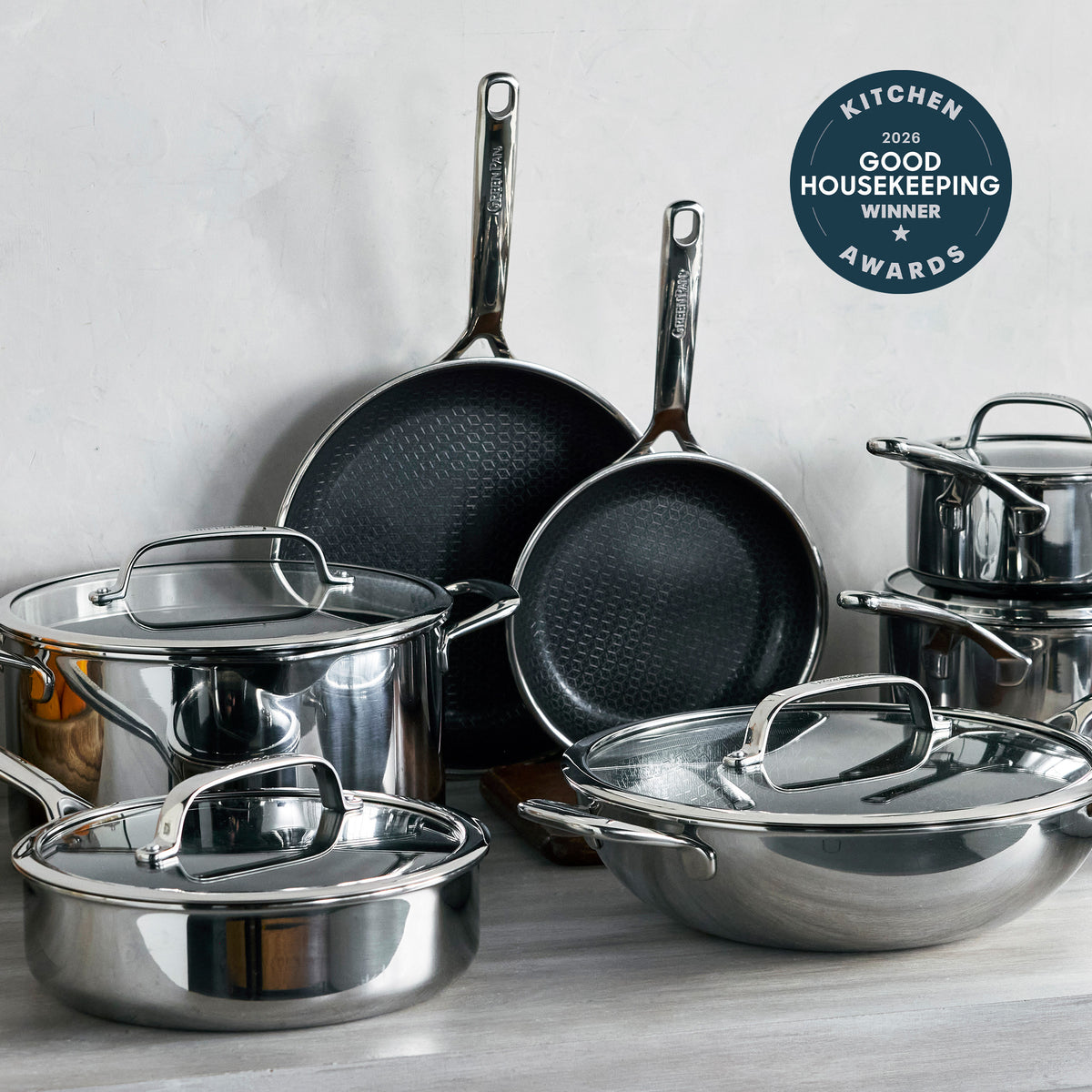 12-piece ceramic nonstick cookware set with lids and handles, featuring a sleek hybrid metal and ceramic design in neutral tones.
