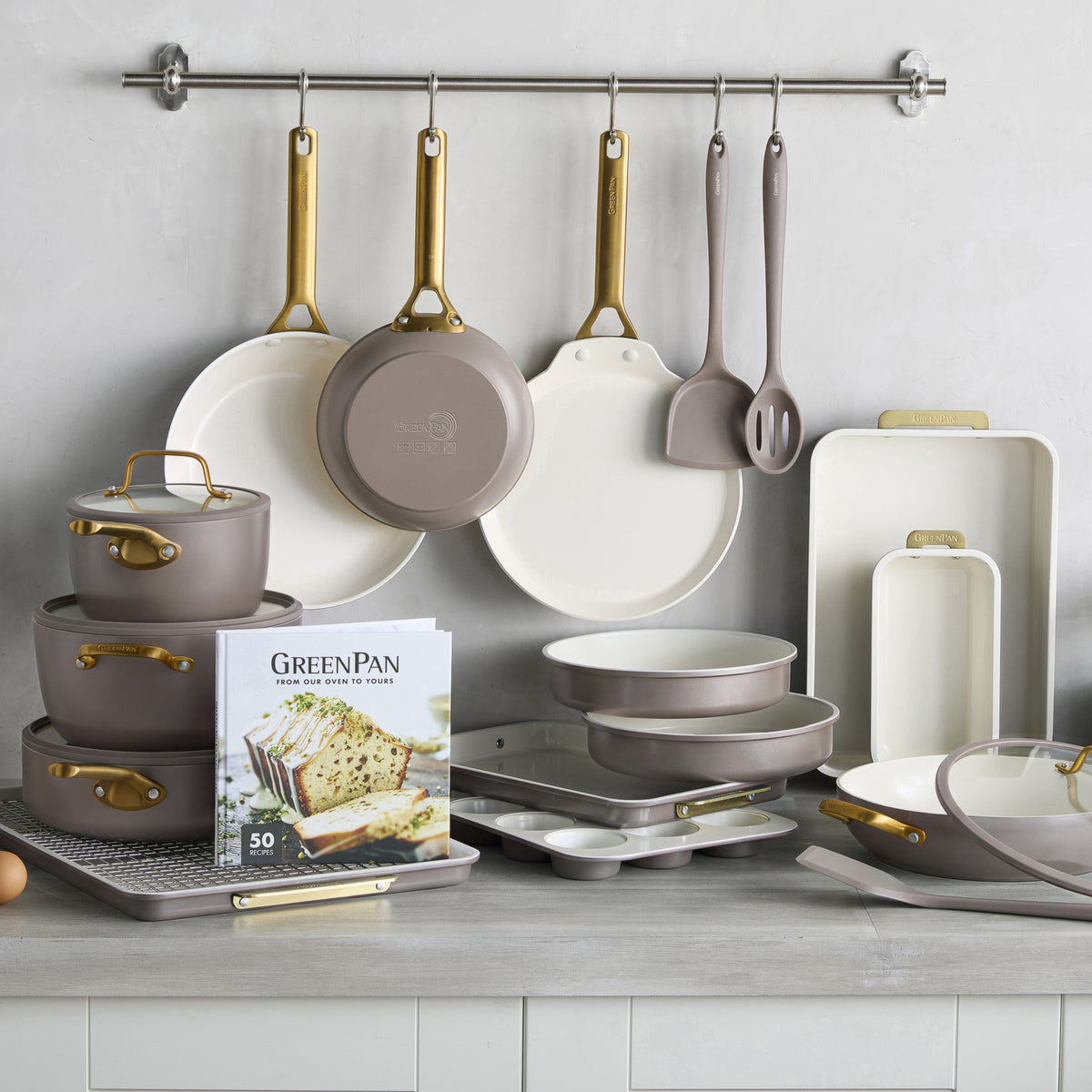 Reserve Pro 22-piece latte-colored cookware and bakeware set including pots, pans, baking sheets, and a recipe book.