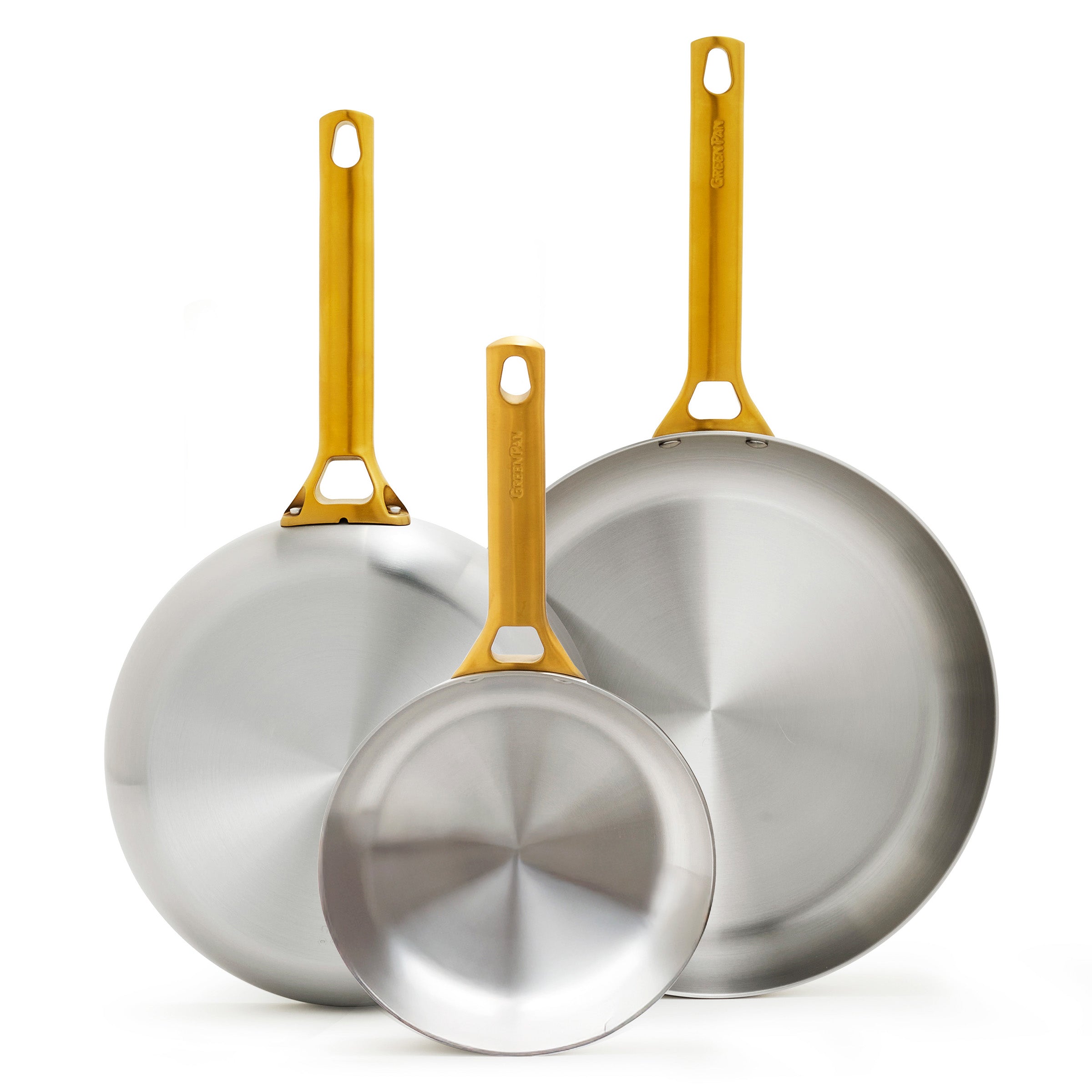 Three stainless steel frying pans with gold handles on a white background