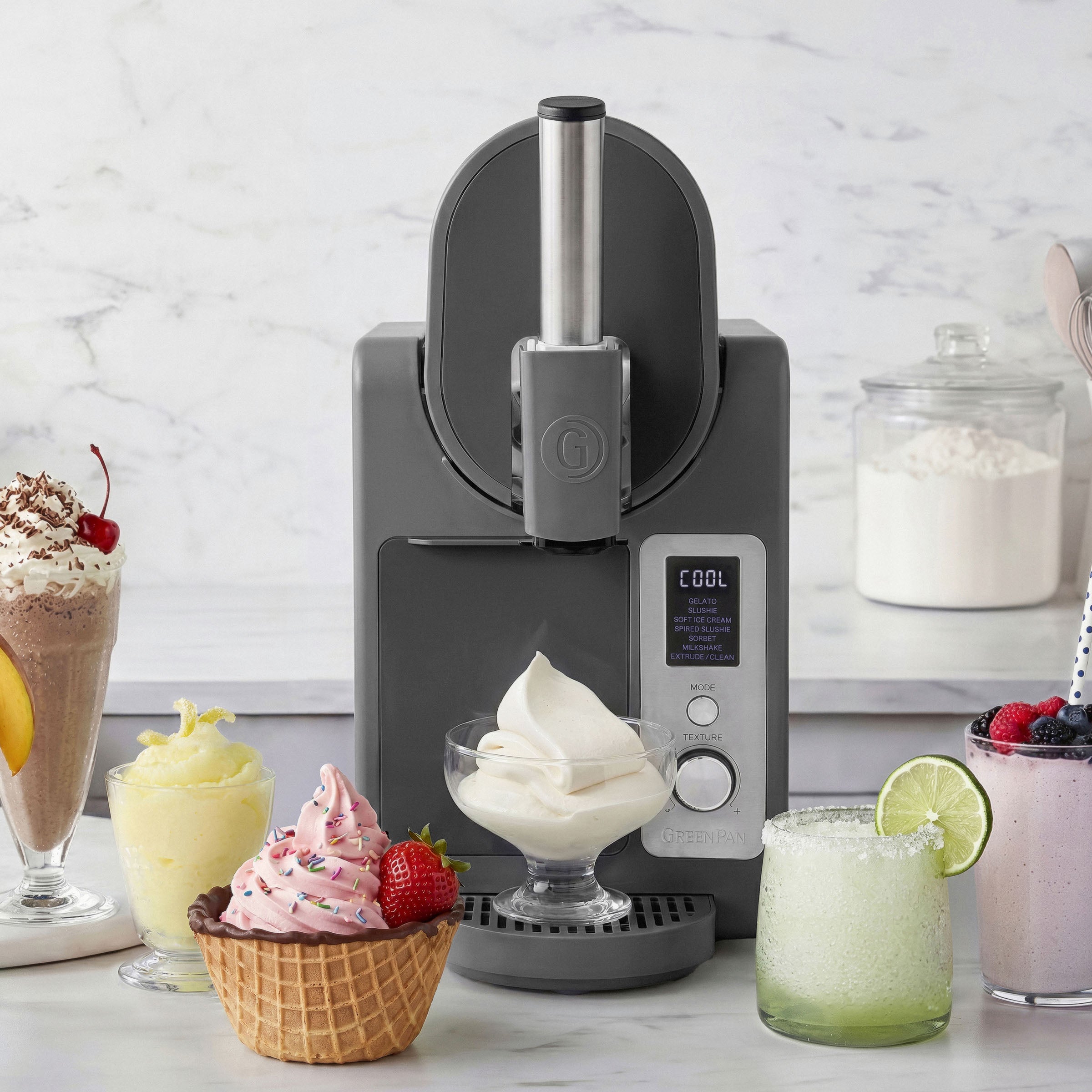 Ice cream maker with ice cream and desserts on a marble countertop