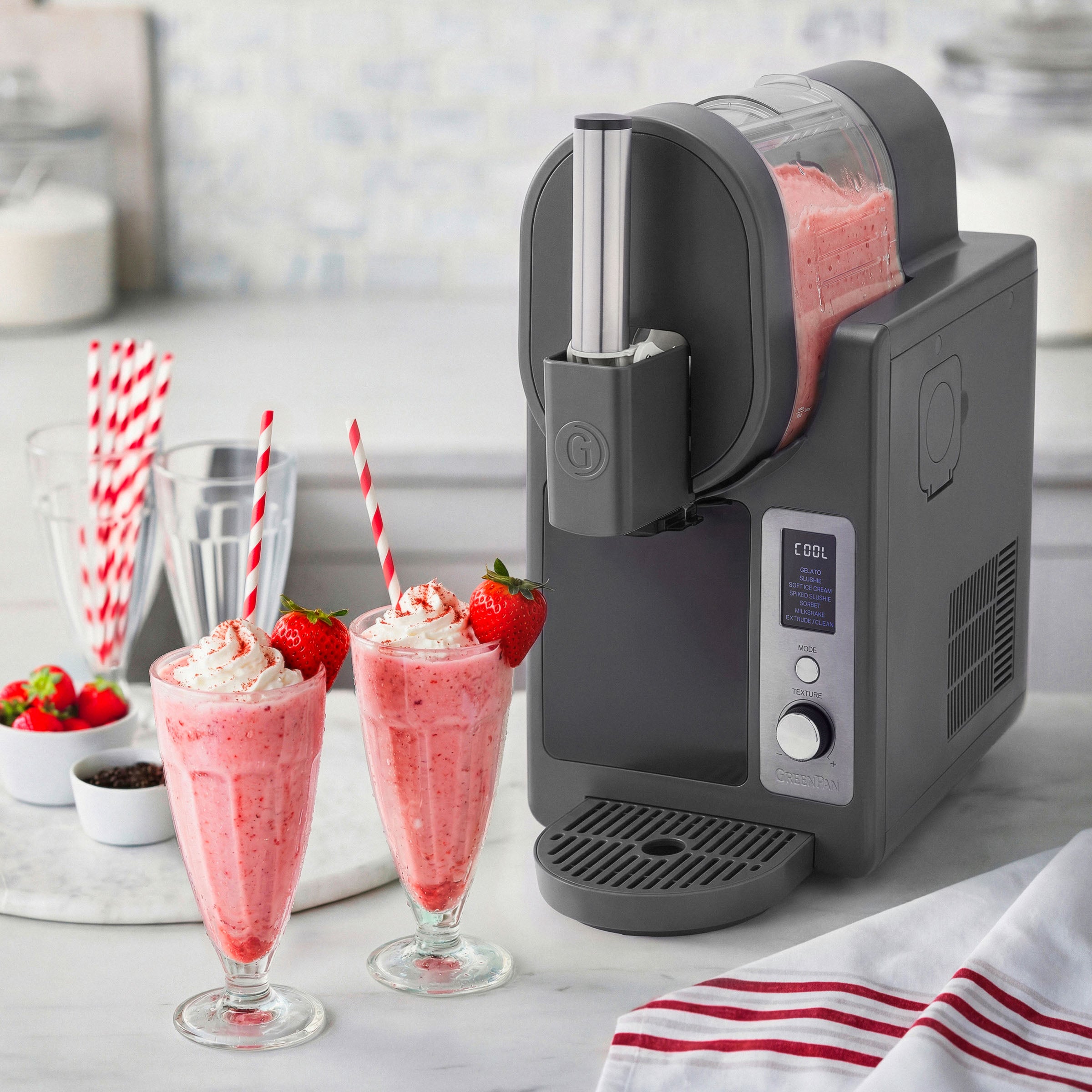 Ice cream machine with strawberry milkshakes on a kitchen counter
