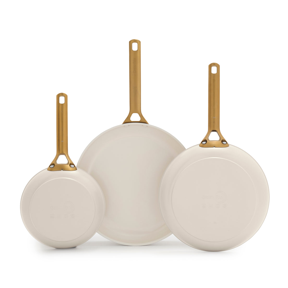 Three cream frying pans with gold handles on a white background