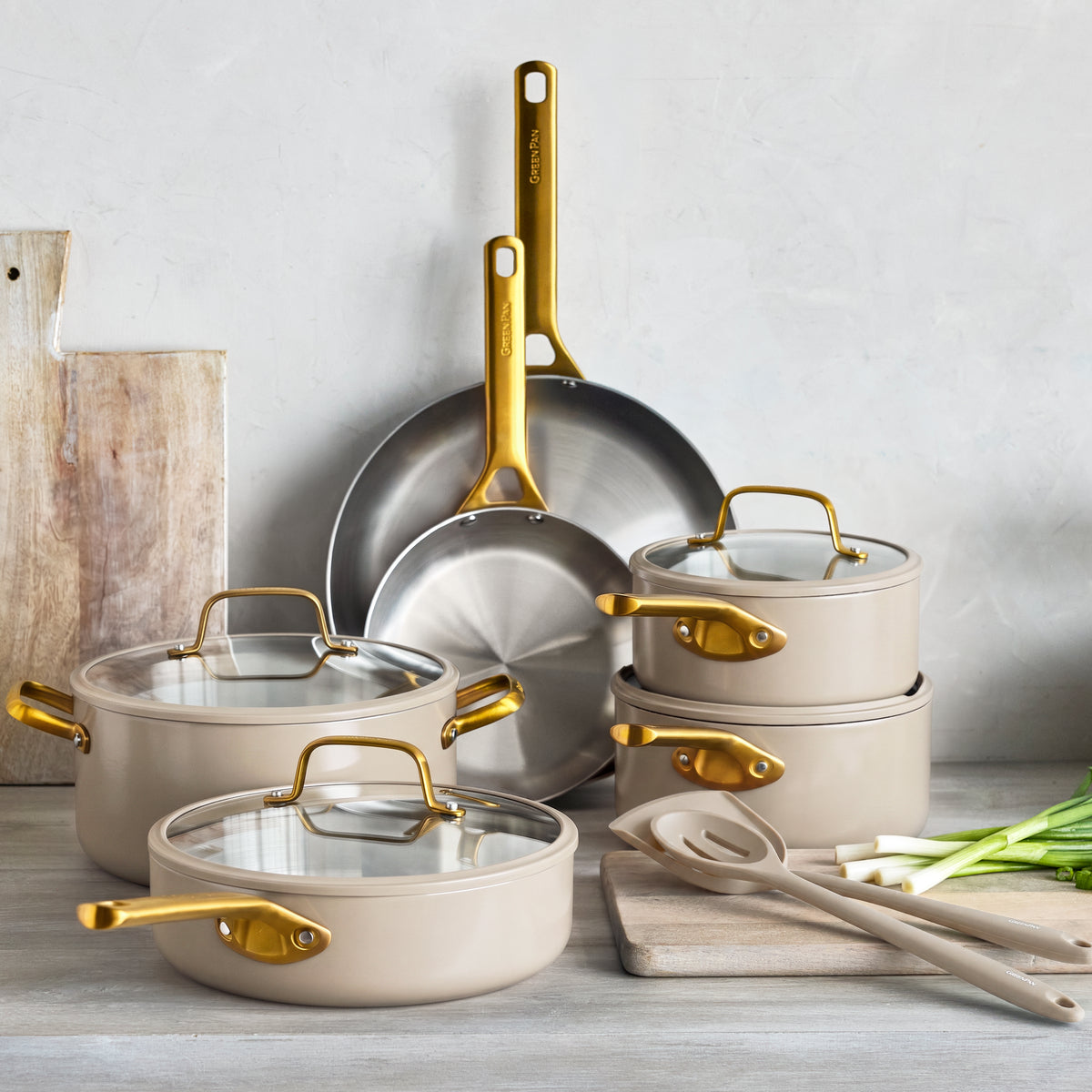 12-piece stainless steel cookware set in macadamia, includes assorted pots, pans, matching lids, and utensils.