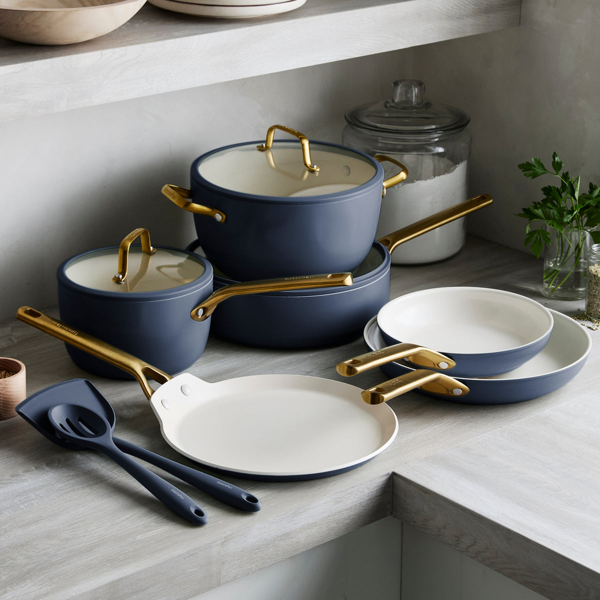 Set of blue cookware with gold handles on a kitchen counter.