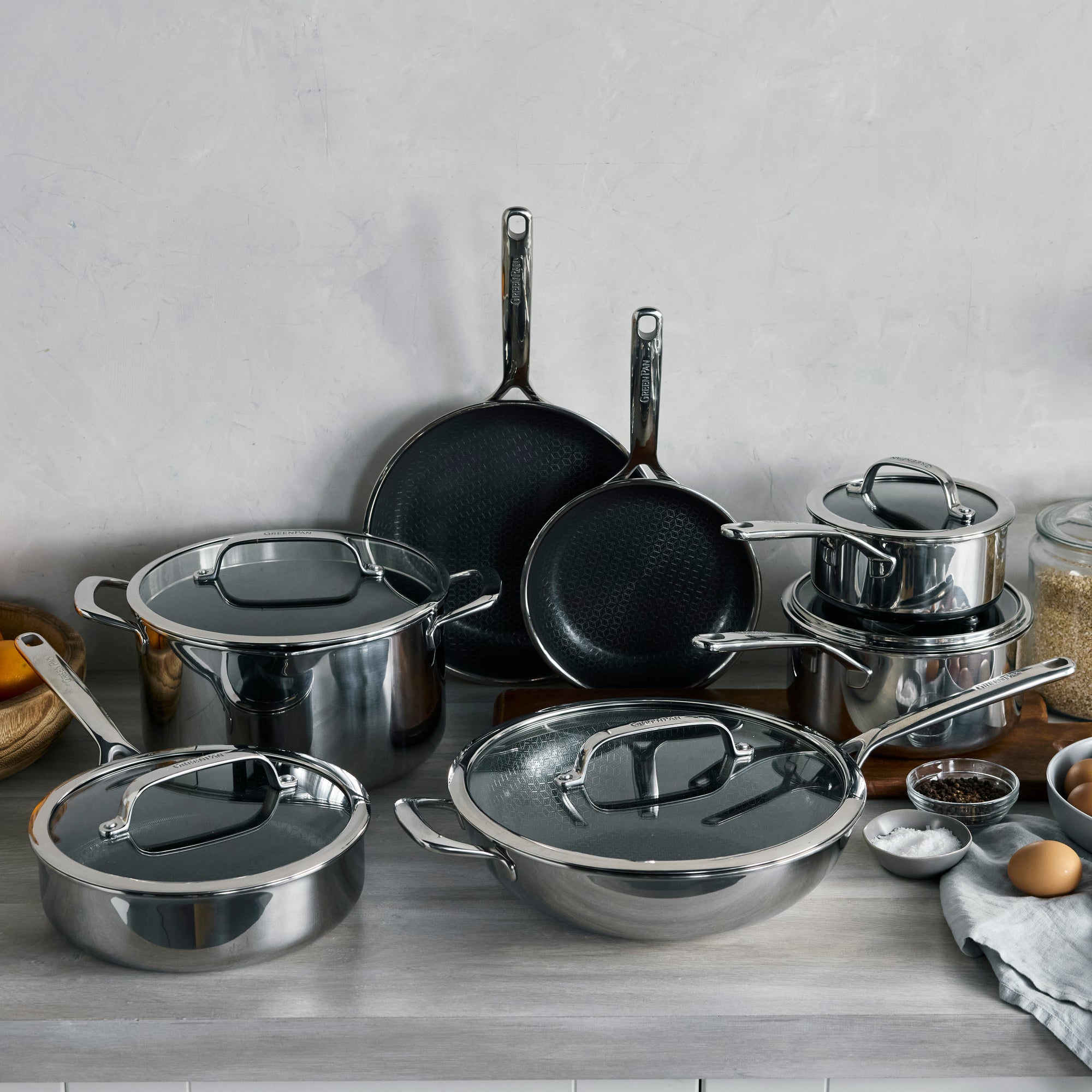 Hybrid ceramic nonstick 12-piece cookware set arranged on a gray countertop.