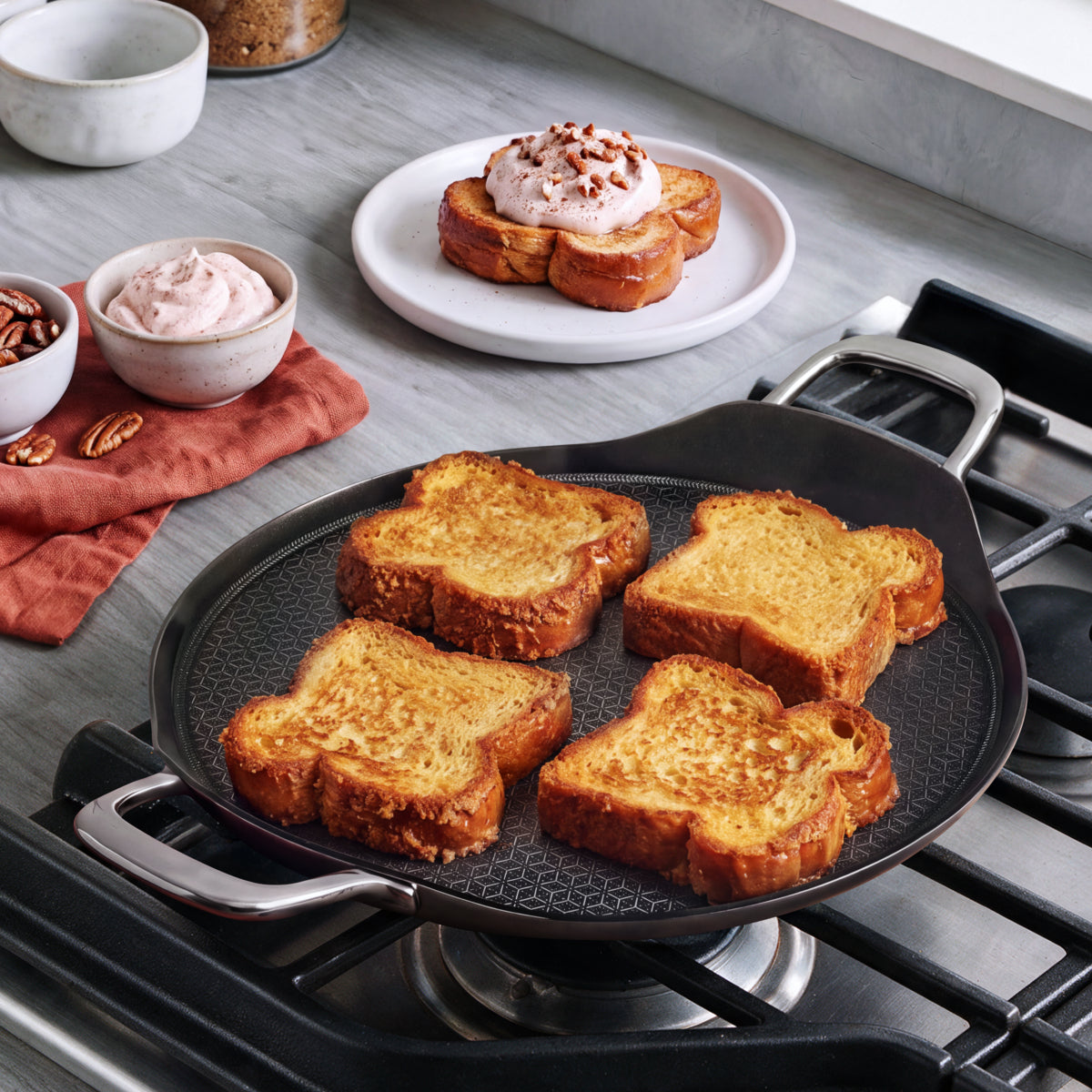 Four slices of French toast cooking on a 13-inch round Spectra Thermobond ceramic nonstick griddle.