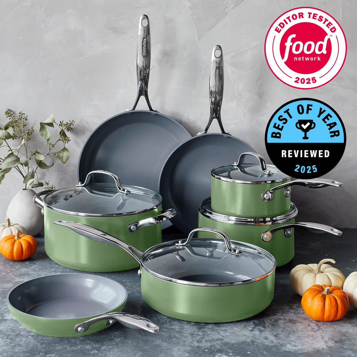 Sage green ceramic nonstick 11-piece cookware set on counter with two pans propped, pumpkins, and Food Network award badges.