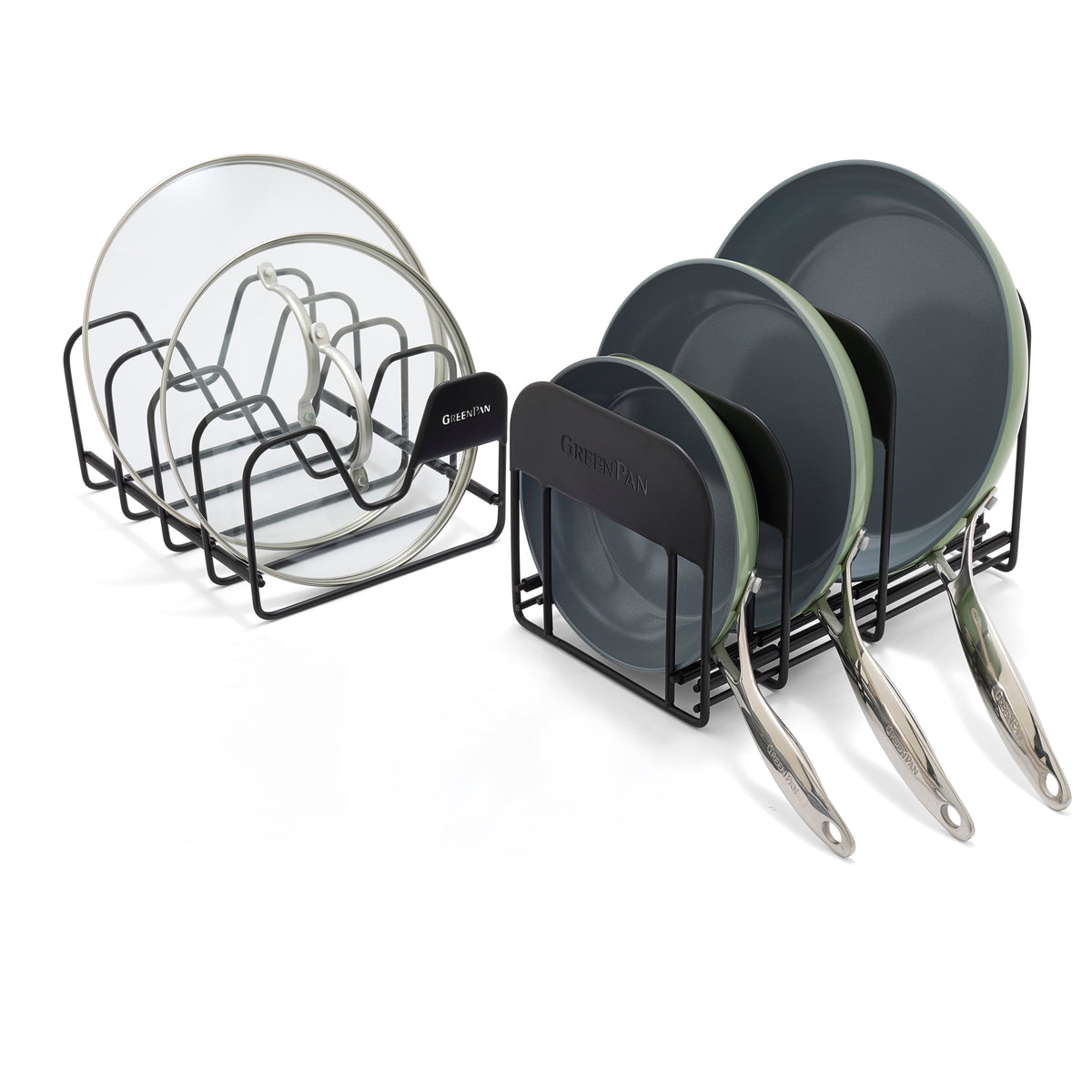 Two black metal racks: one holds glass pot lids, the other stores three grey Valencia Pro frying pans vertically.