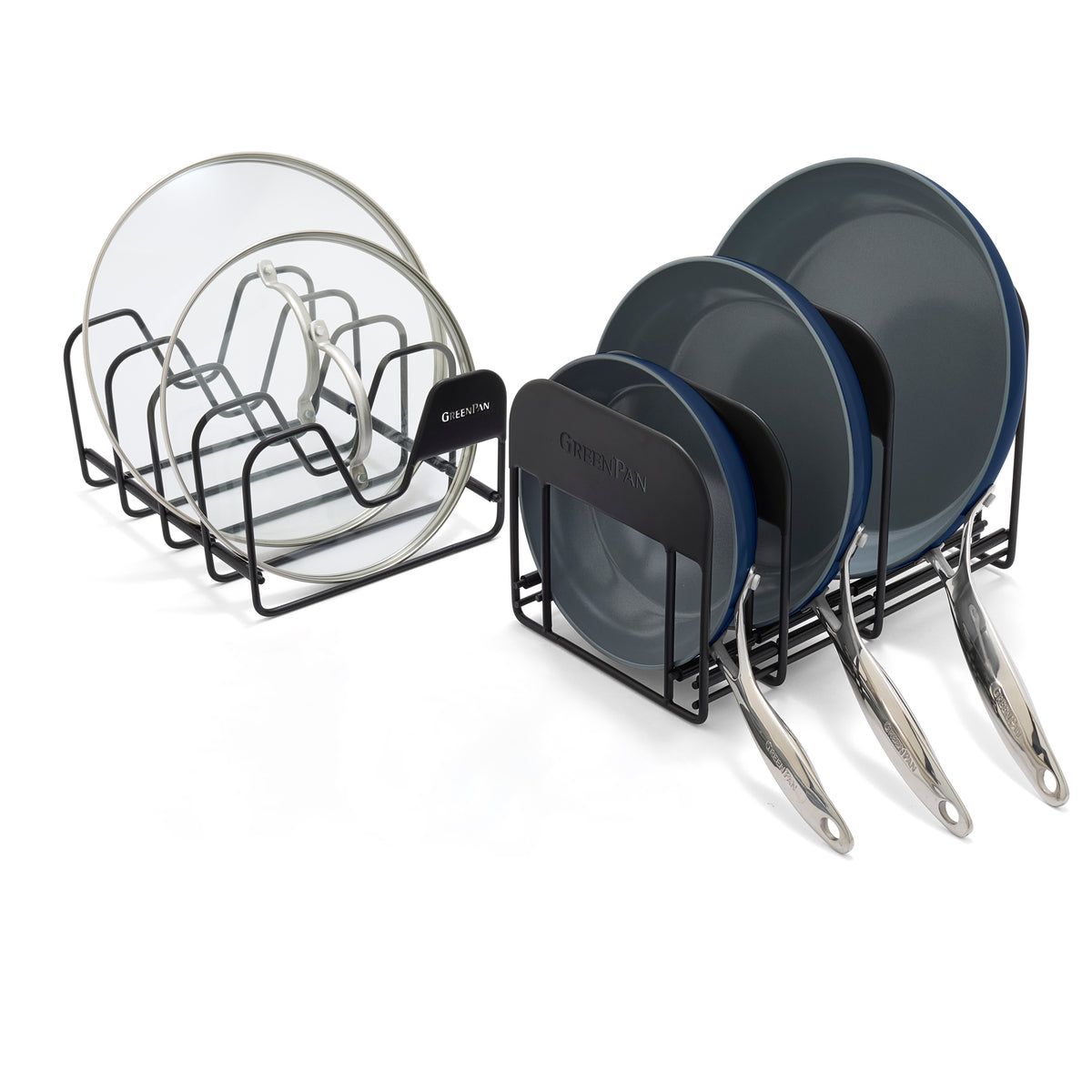 Two black racks holding glass lids and a dark blue Valencia Pro frypan set arranged neatly on a white surface.