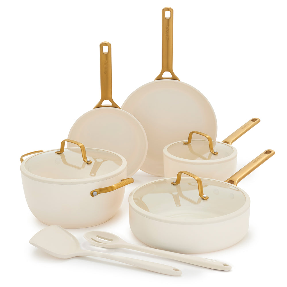 Set of cream cookware with gold handles on a white background