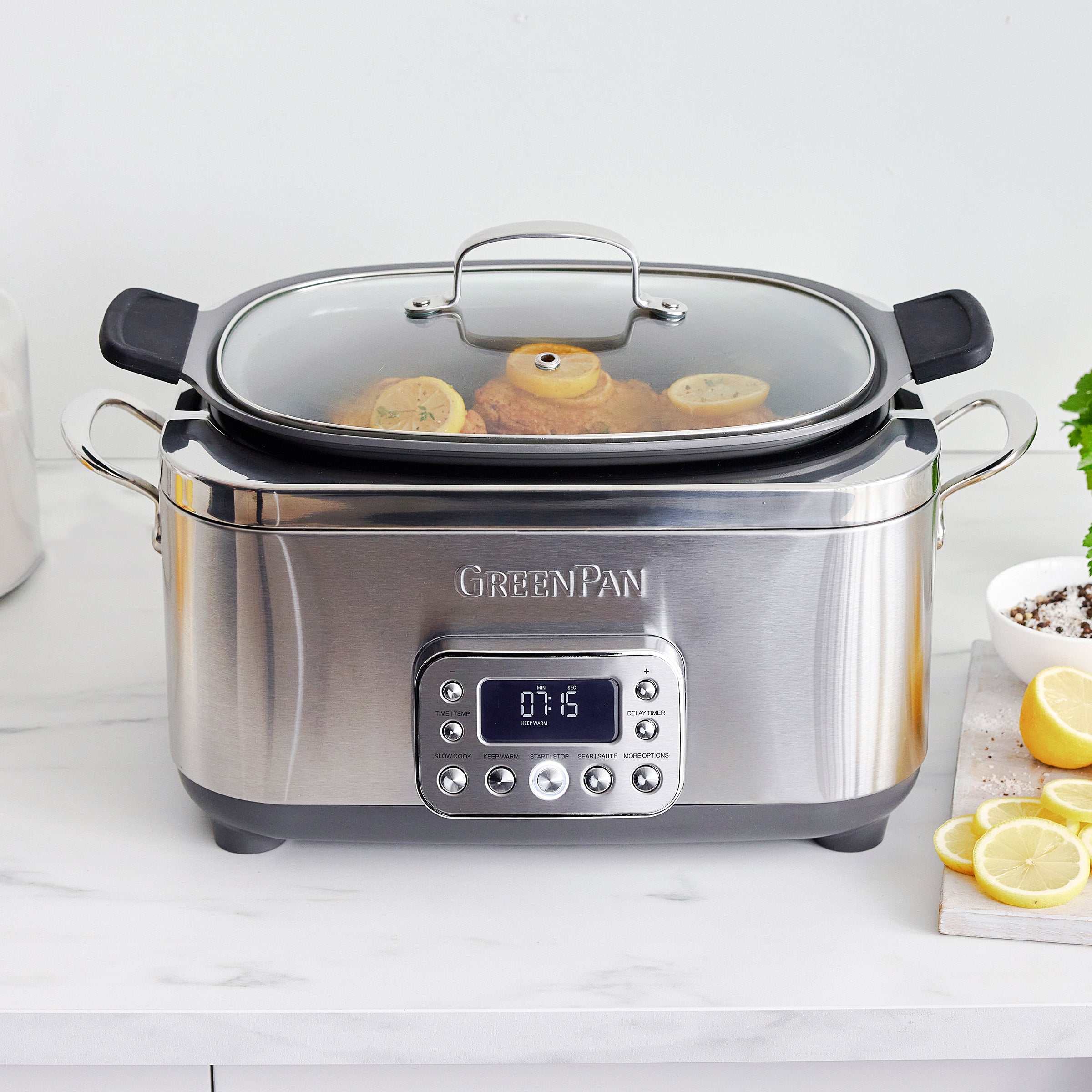 Stainless steel slow cooker with digital display on a white countertop