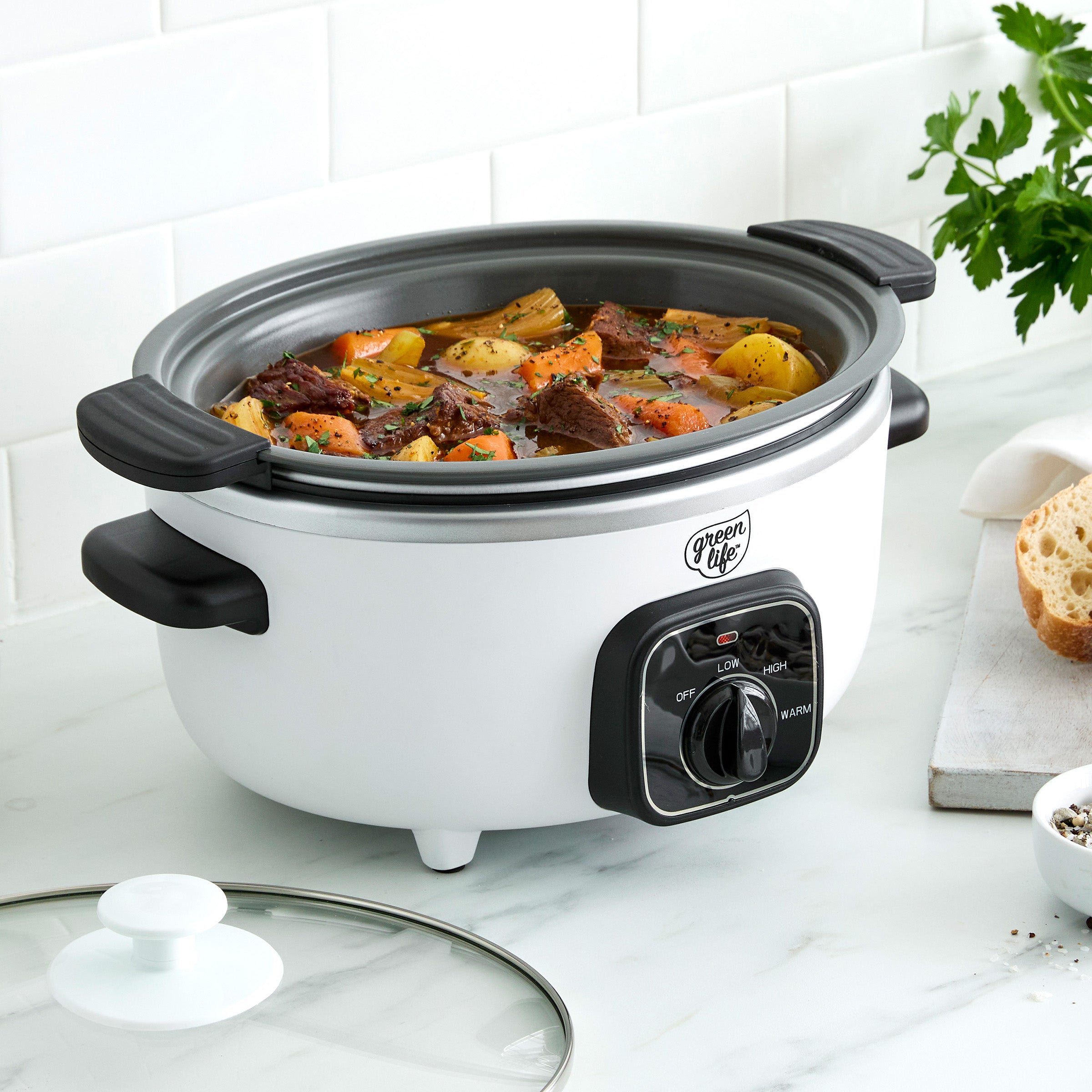 White slow cooker with food inside on a kitchen counter