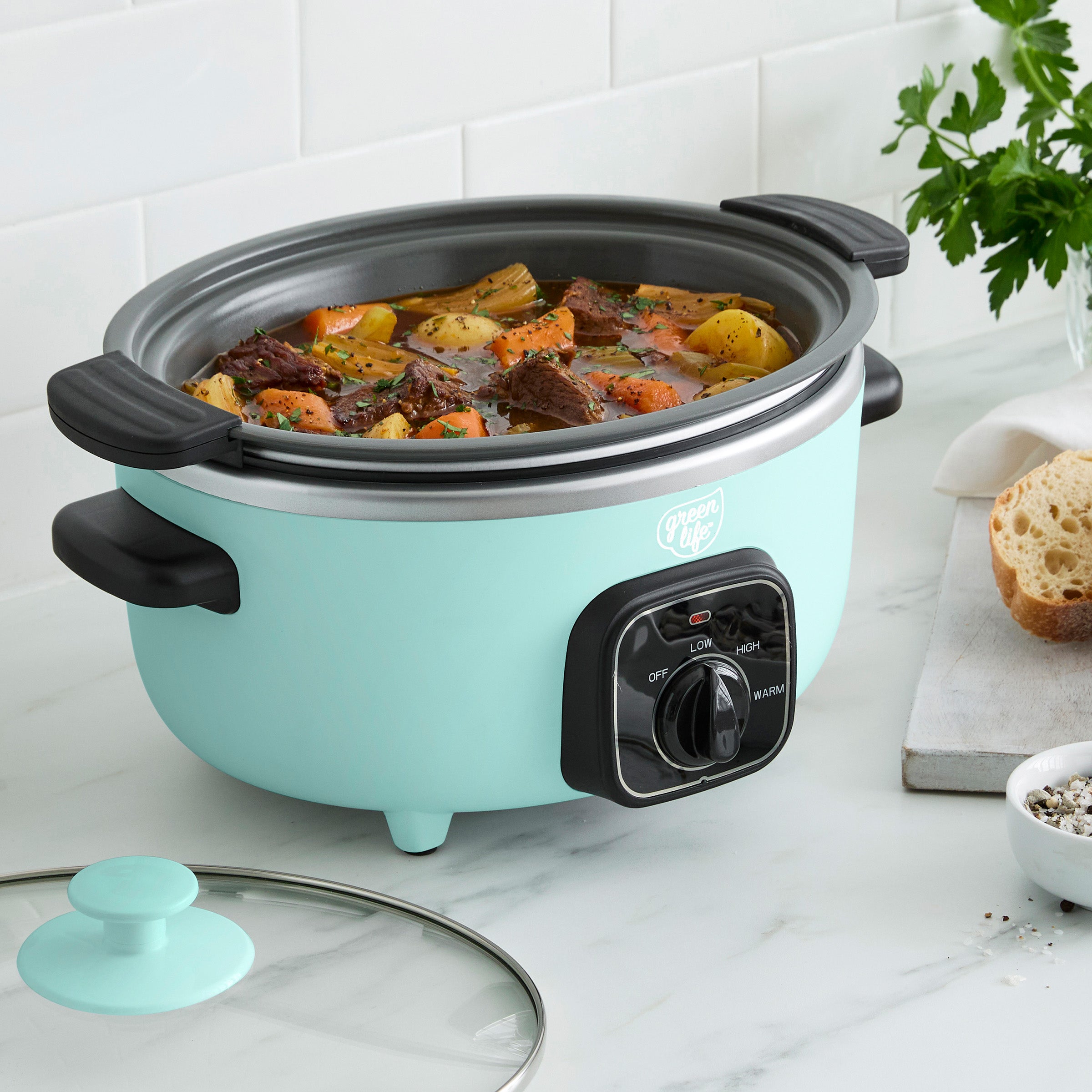 Turquoise slow cooker with beef stew on a kitchen counter