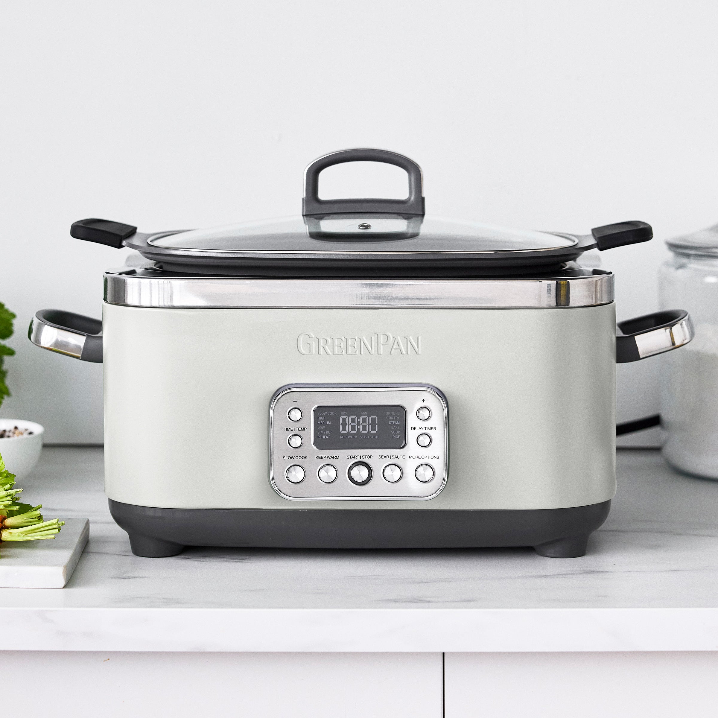Cream slow cooker with digital display on a white countertop
