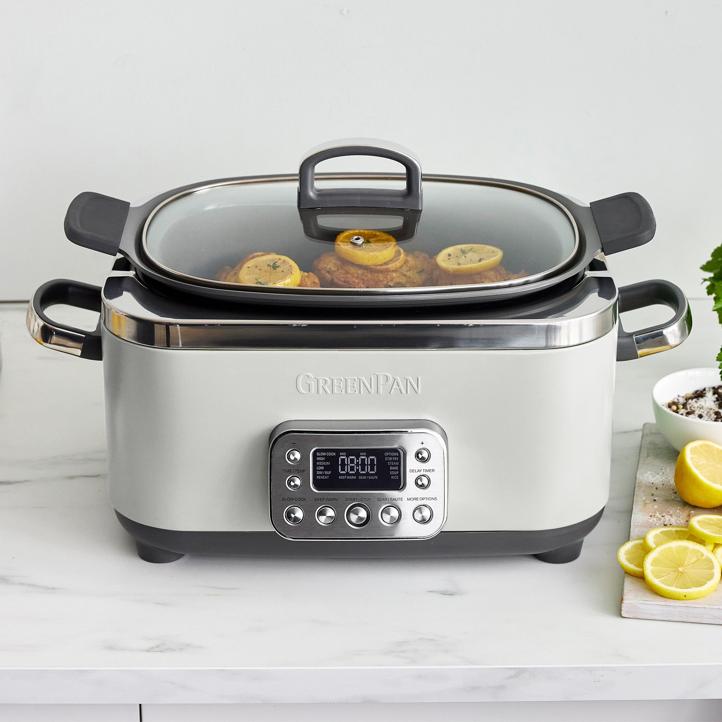 Cream slow cooker with digital display on a white countertop