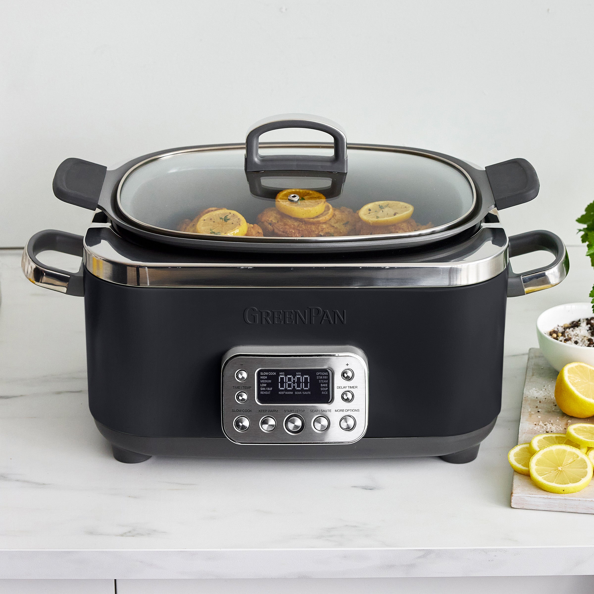 Black slow cooker with digital display on a white countertop