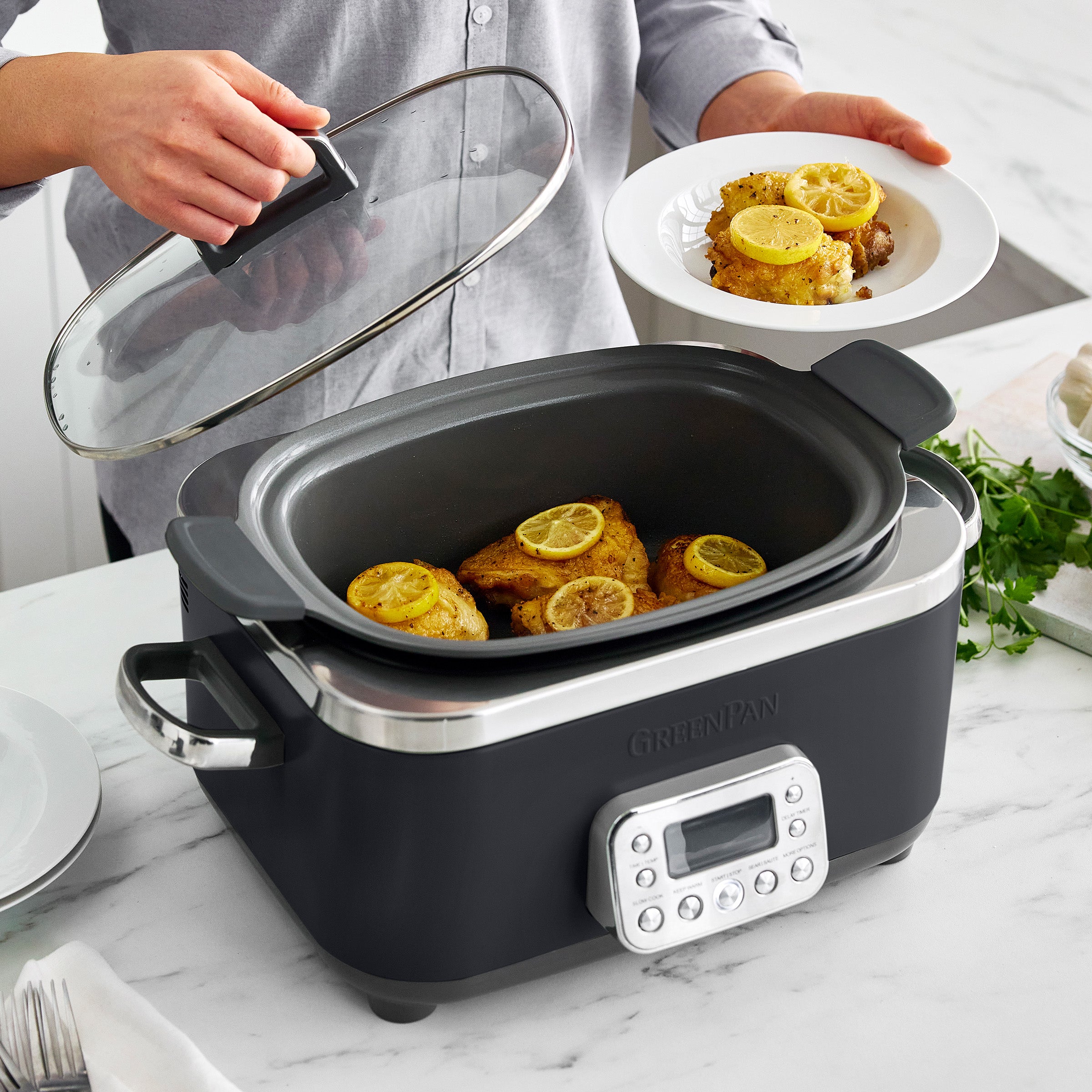Slow cooker with meat inside, person holding clear lid