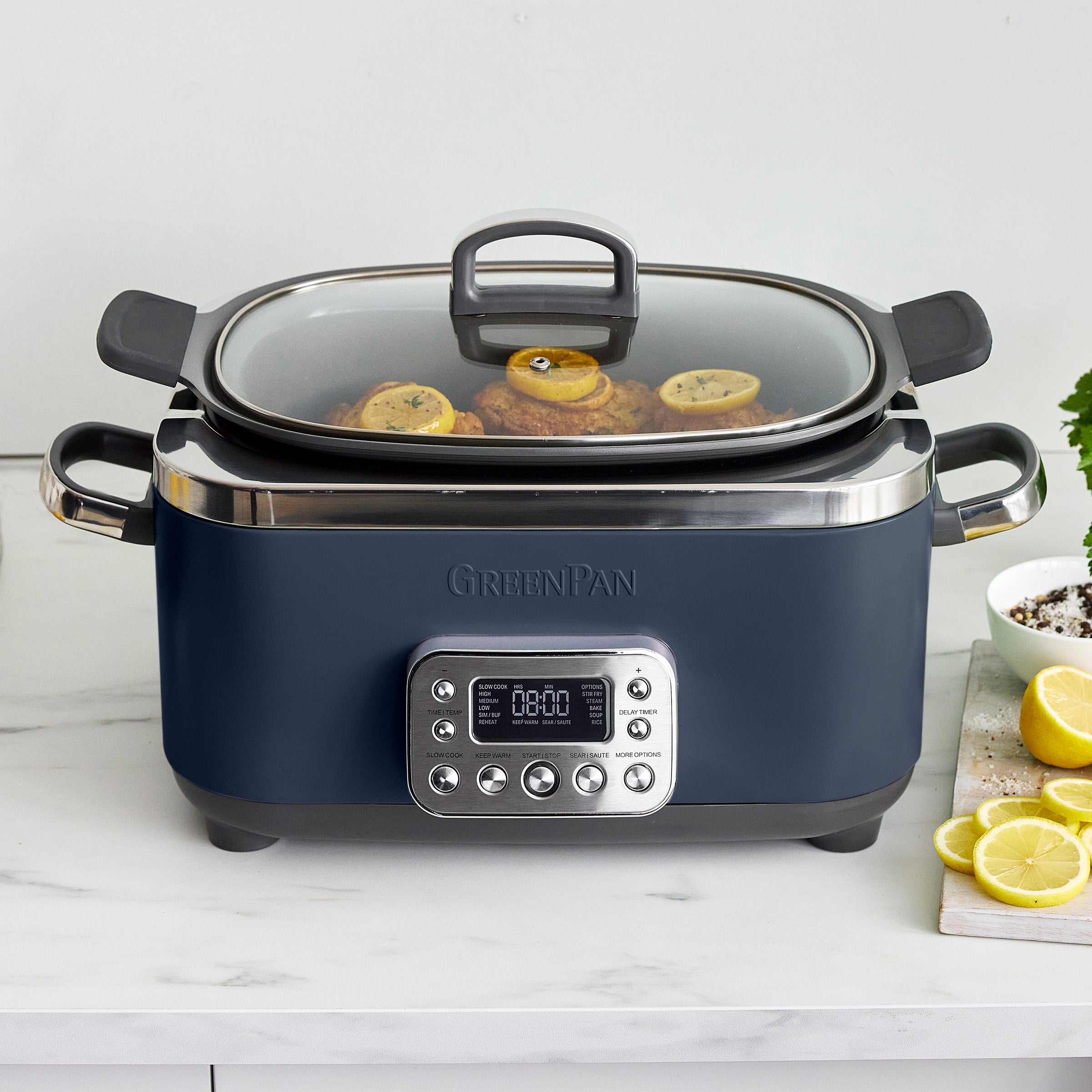 Blue slow cooker with digital display on a white countertop