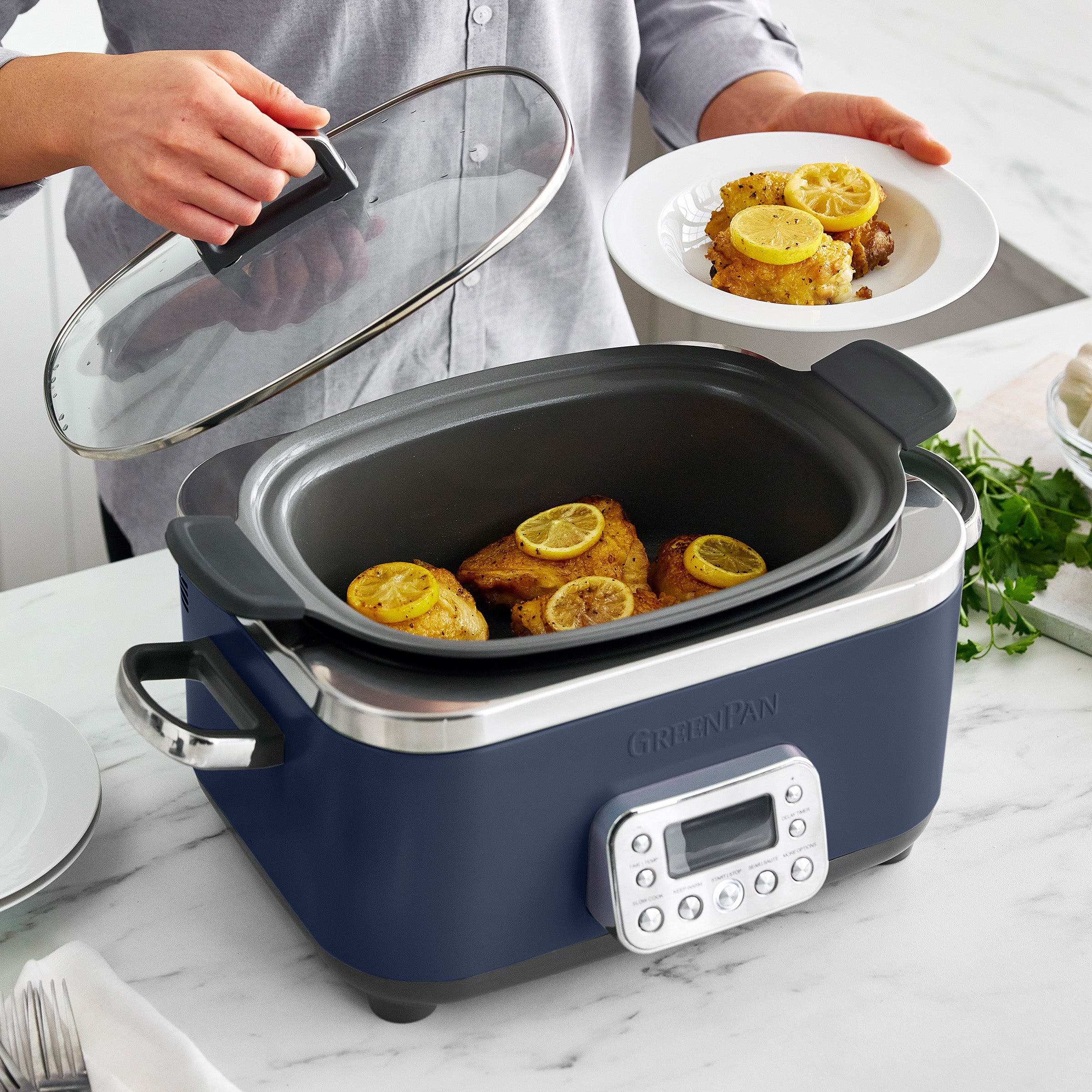 Slow cooker with meat inside, person holding clear lid