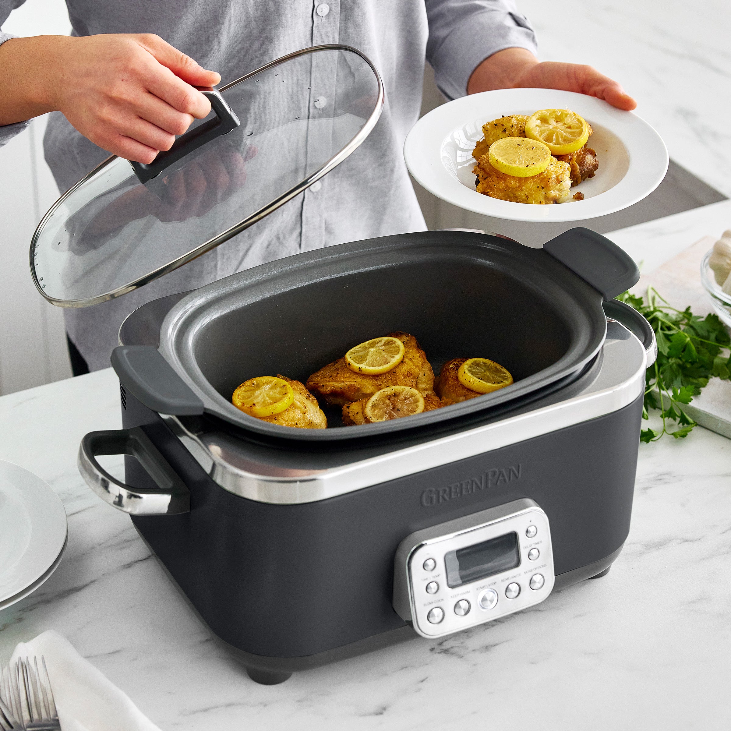 Slow cooker with meat inside, person holding clear lid
