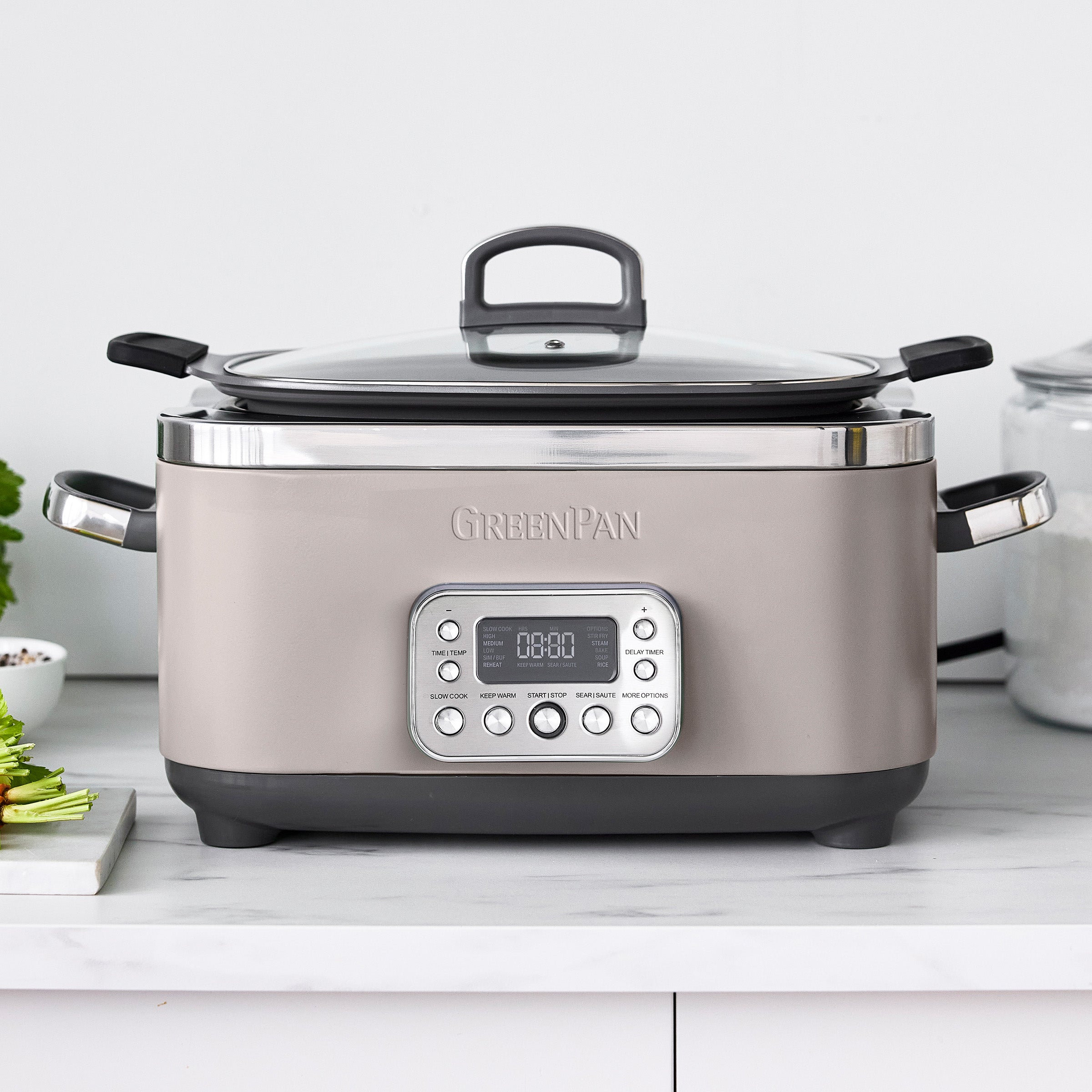 Taupe slow cooker on a kitchen counter with a white background
