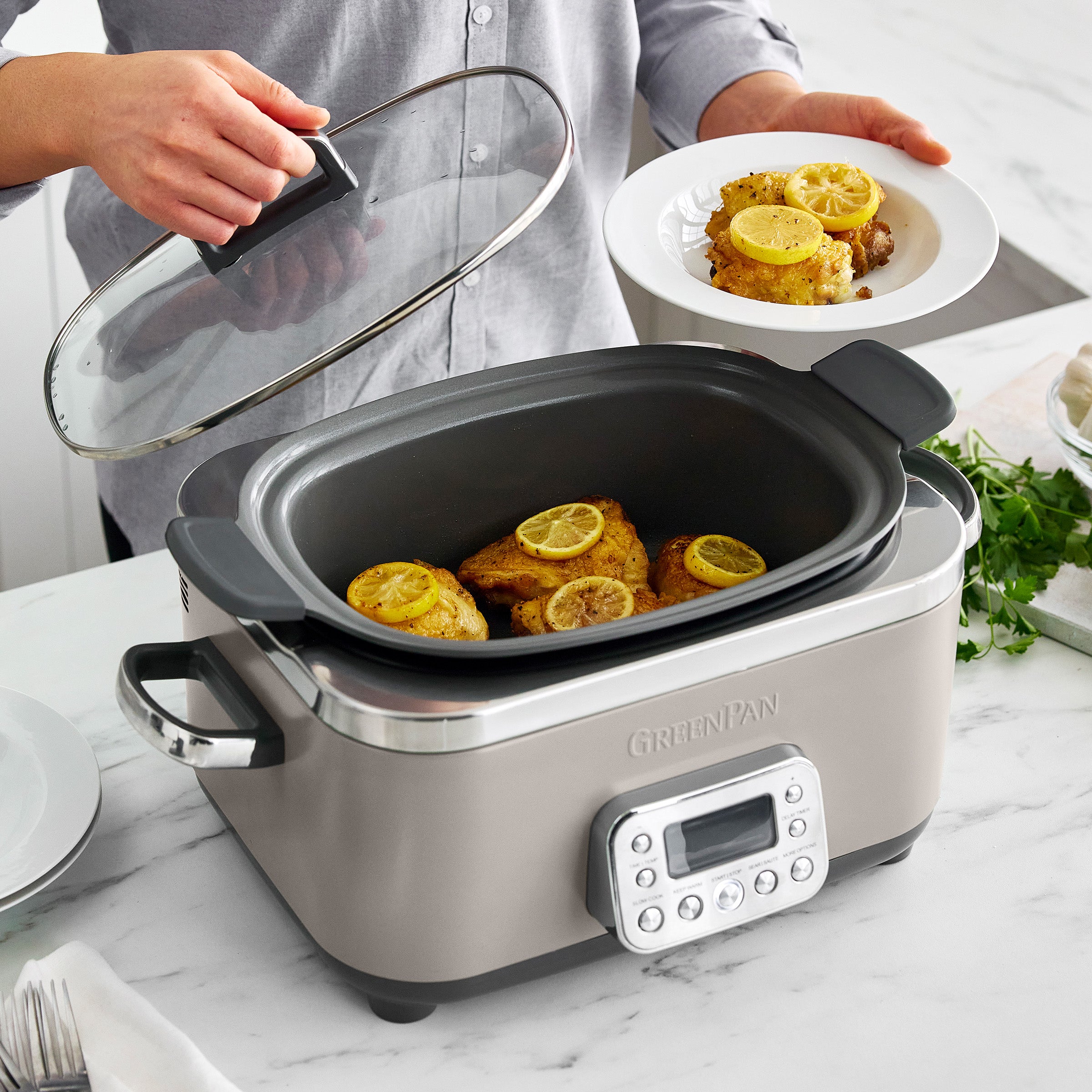 Slow cooker with meat inside, person holding clear lid