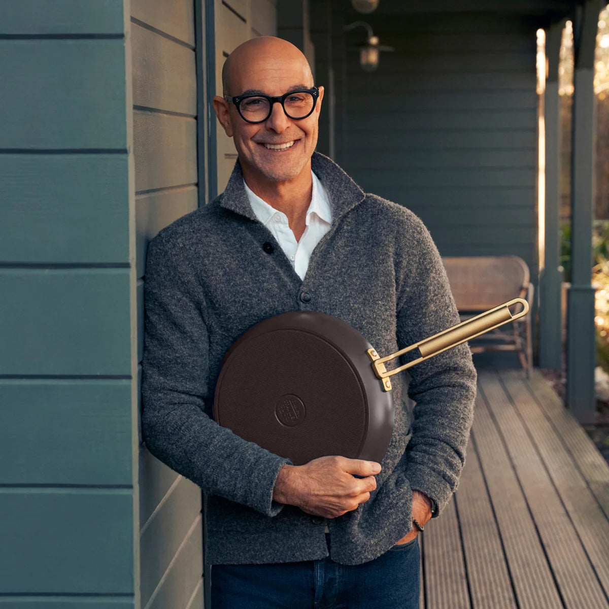 Stanley Tucci holding an Espresso 10-inch ceramic crepe and omelette pan with a gold-tone handle.