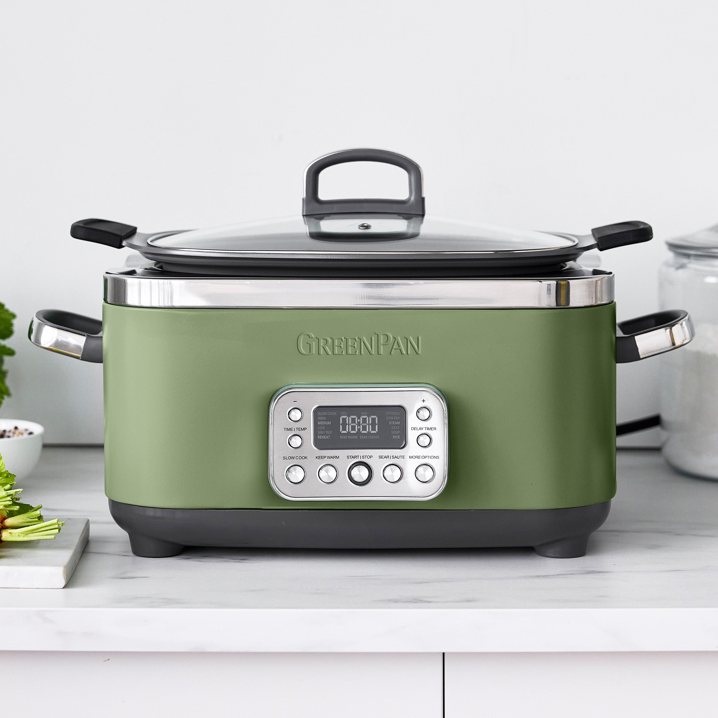 Green slow cooker with digital display on a white countertop