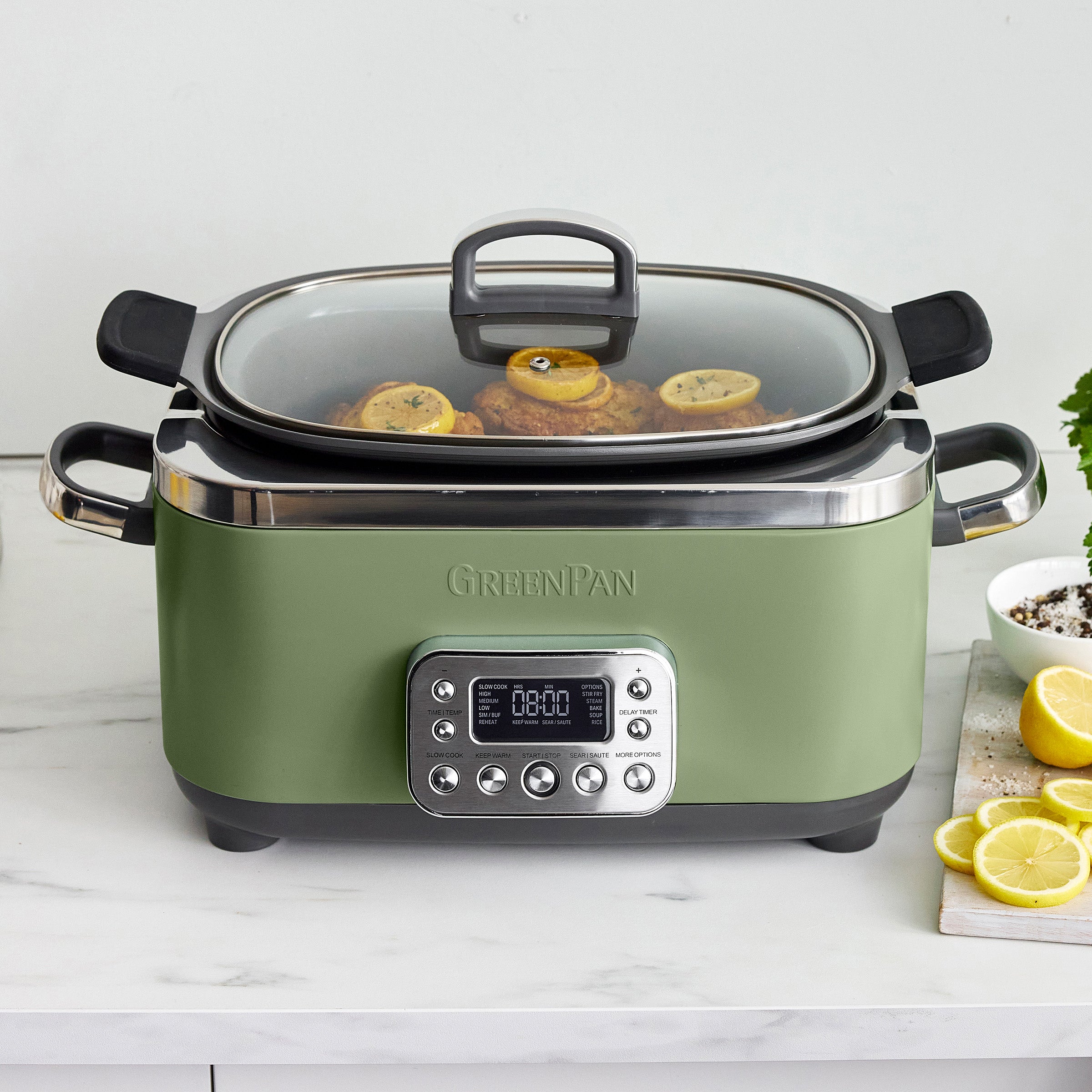Green slow cooker with digital display on a white countertop