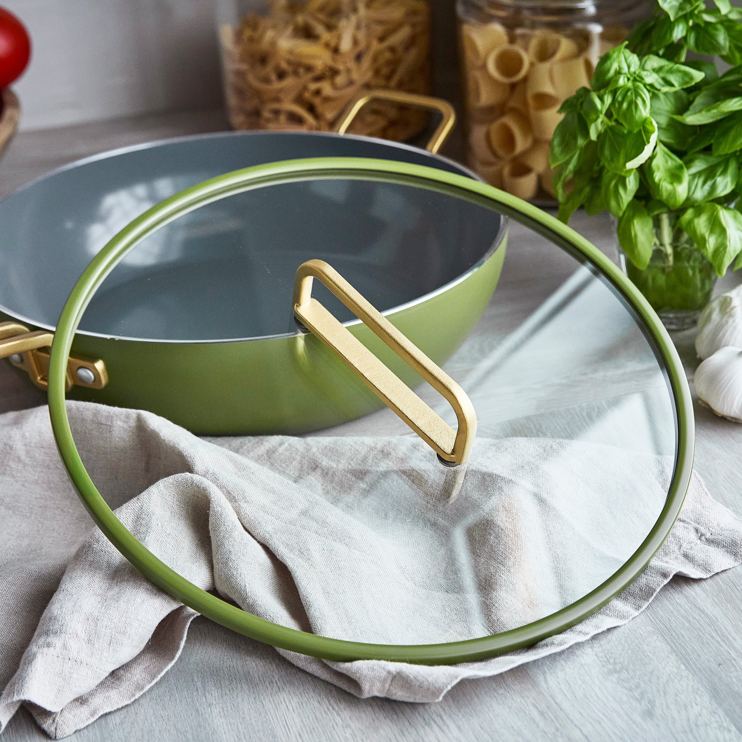 Green saurw pan with lid on a kitchen counter