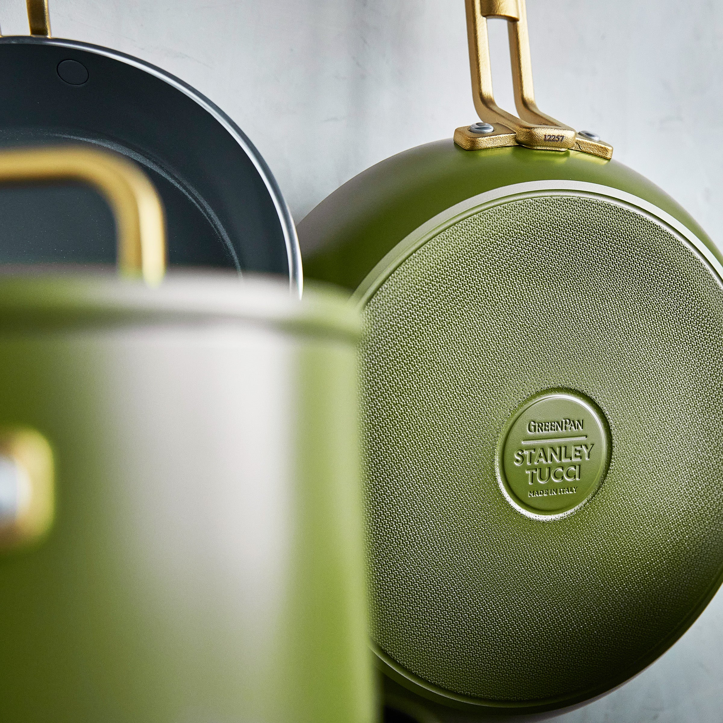 Green cookware set with 'Stanley Tucci' branding on a light gray background