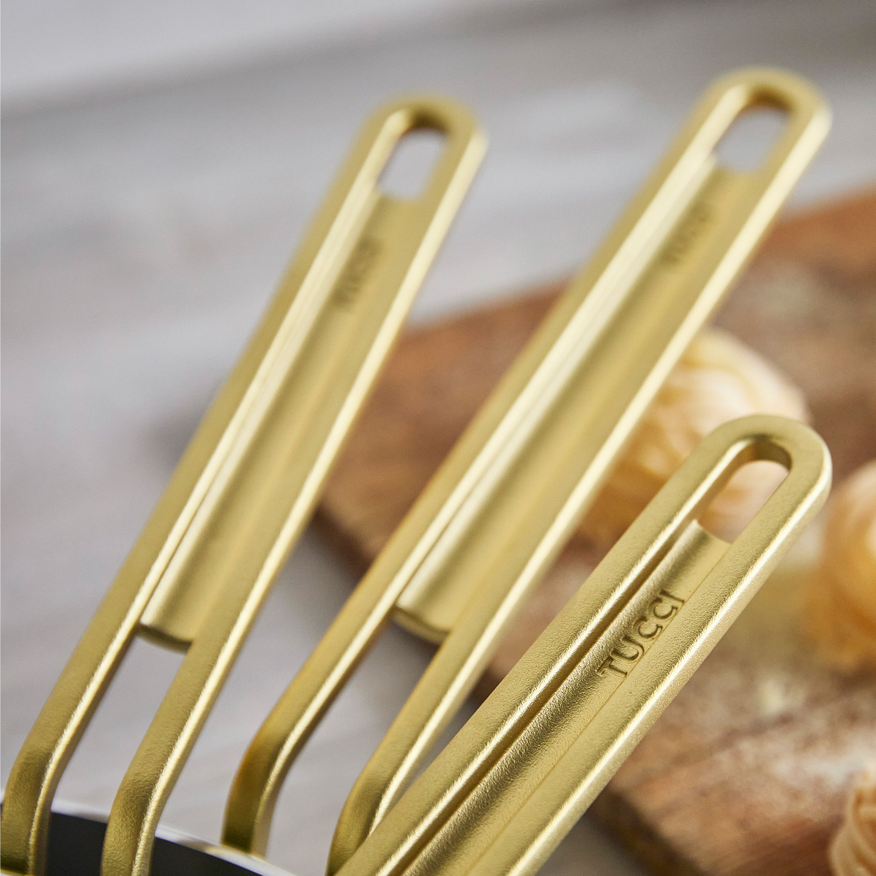 Gold frypan handles on a blurred background