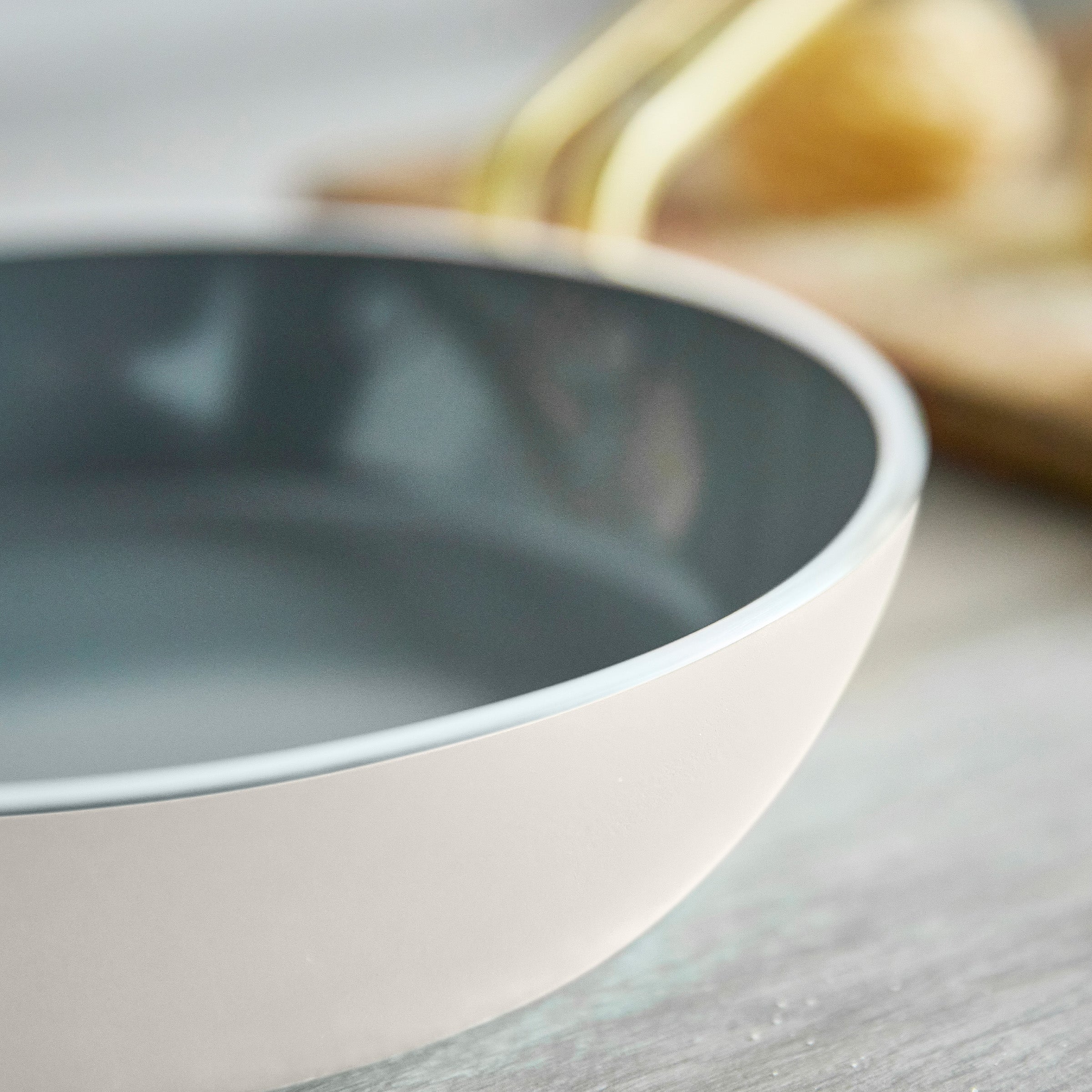 Close-up of a white frypan on a wooden surface