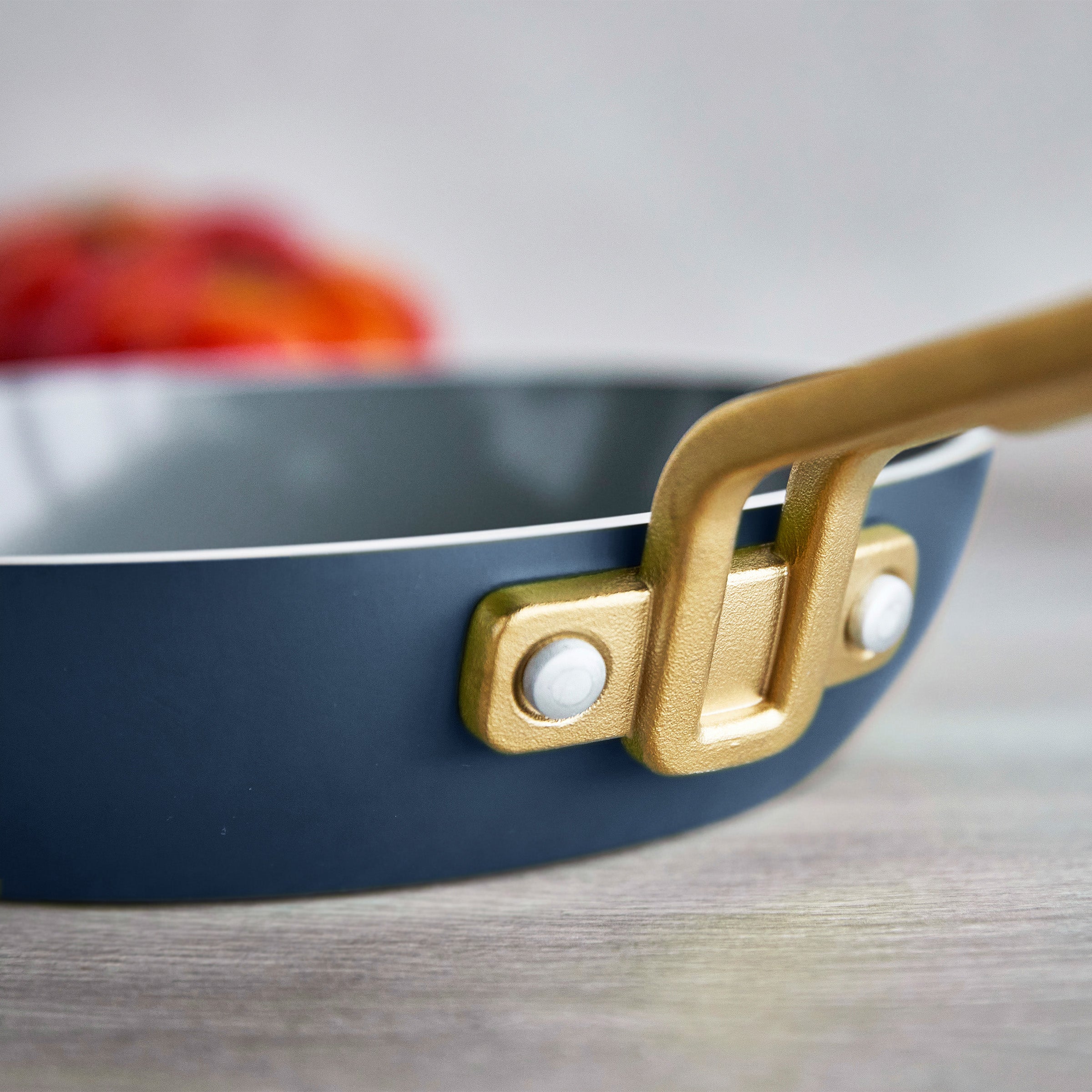 Close-up of a blue frying pan with a gold handle