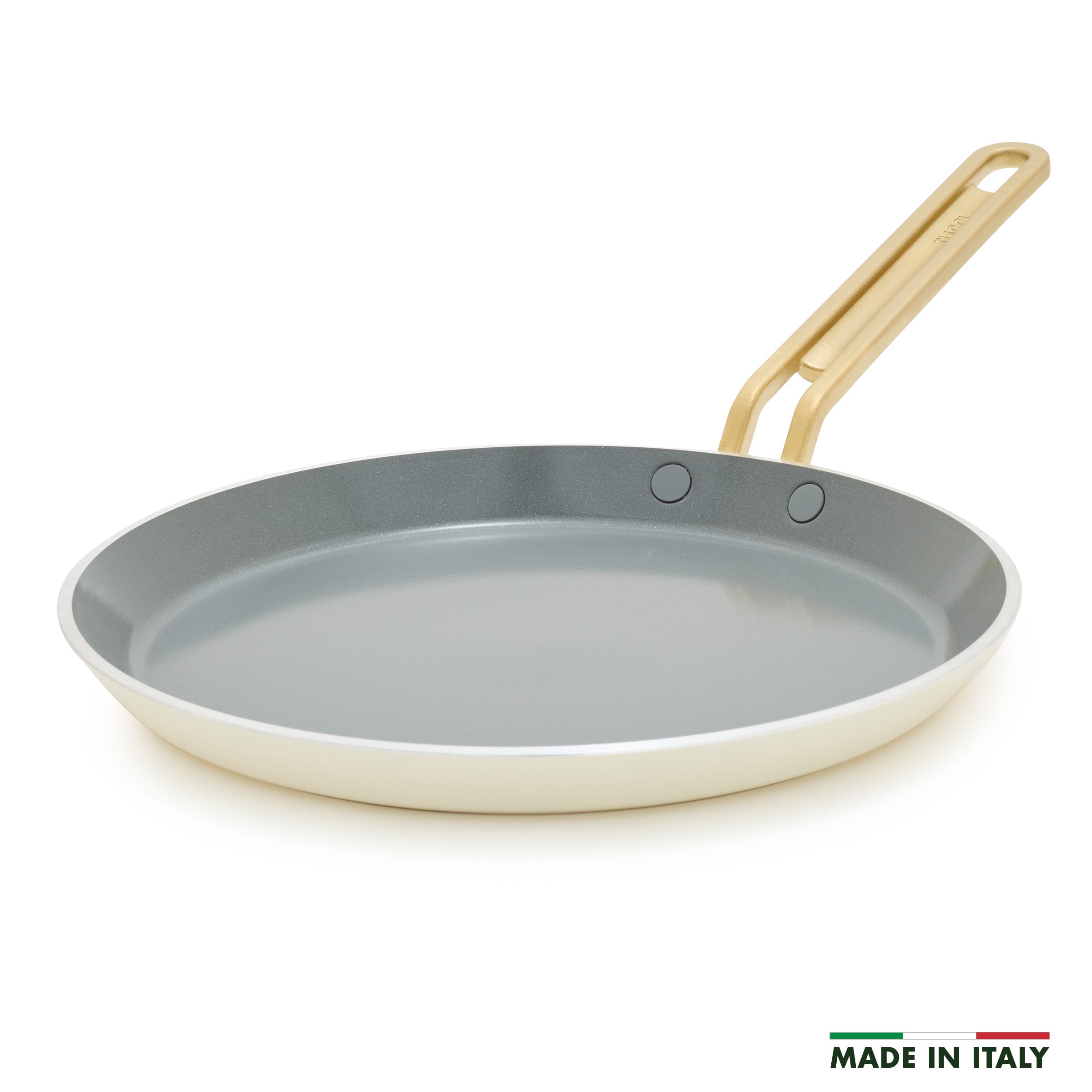 White crepe pan with a gold handle on a white background