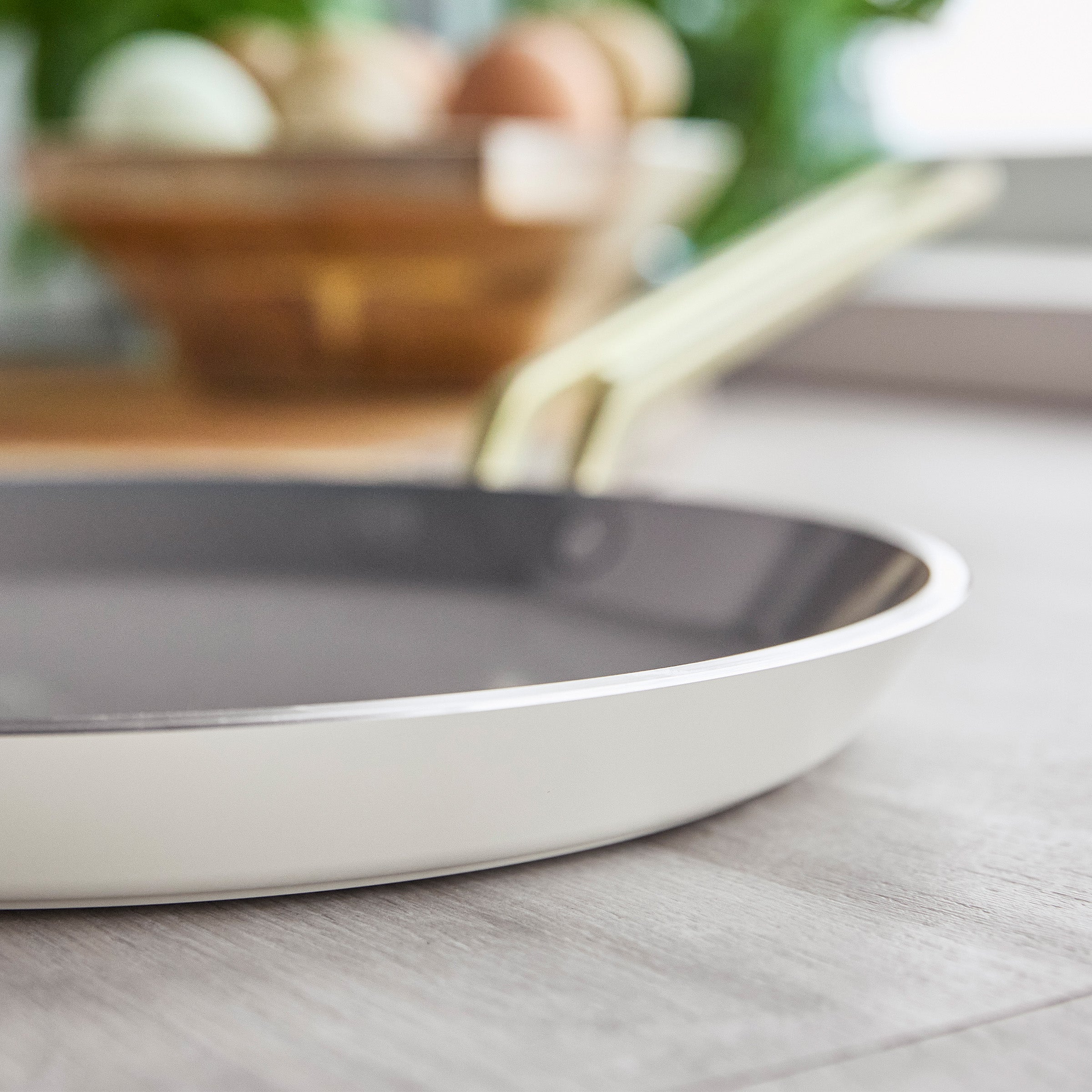 White crepe pan on a wooden surface with a blurred background