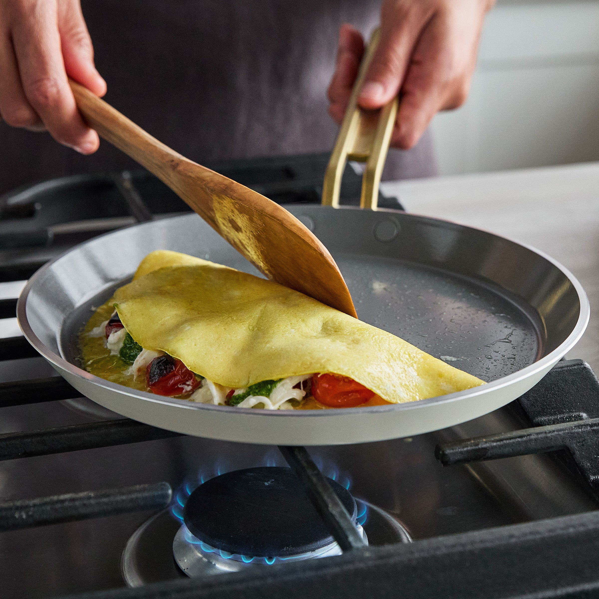 Crepe being folded in a pan on a stove